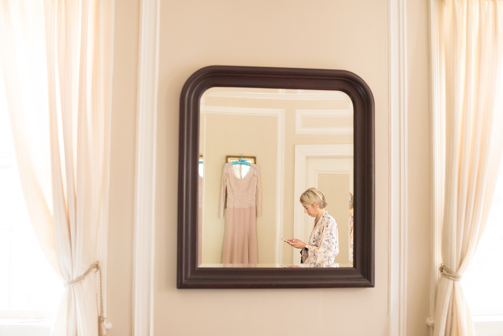 Mikkel Paige Photography photos of a wedding at Crabtree Kittle's House. Picture of the bride getting ready with her wedding dress reflecting in a mirror.