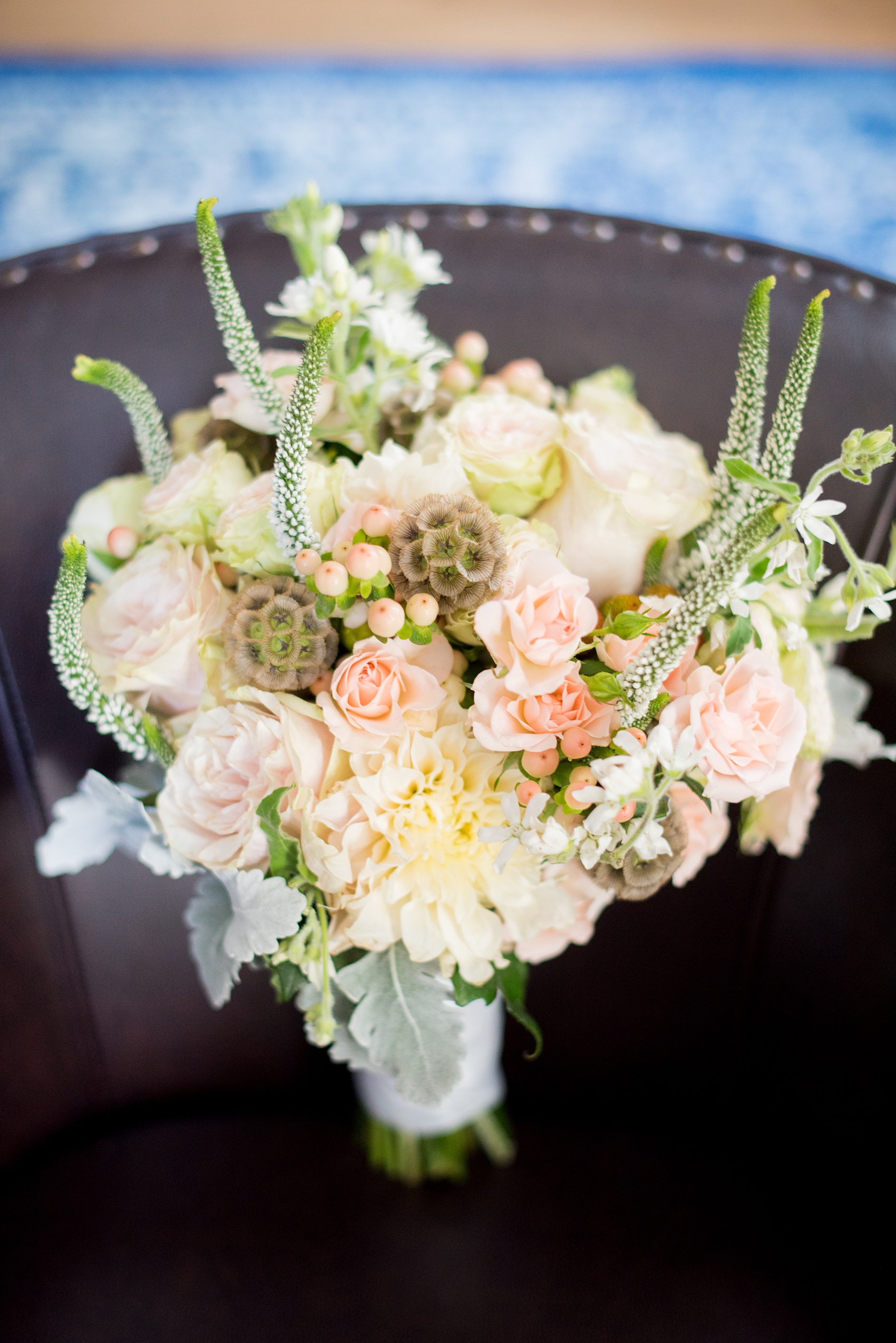 Mikkel Paige Photography photos of a wedding at Crabtree Kittle's House. Picture of the bride's bouquet. Includes scabiosa, spray roses, dusty miller and garden roses.