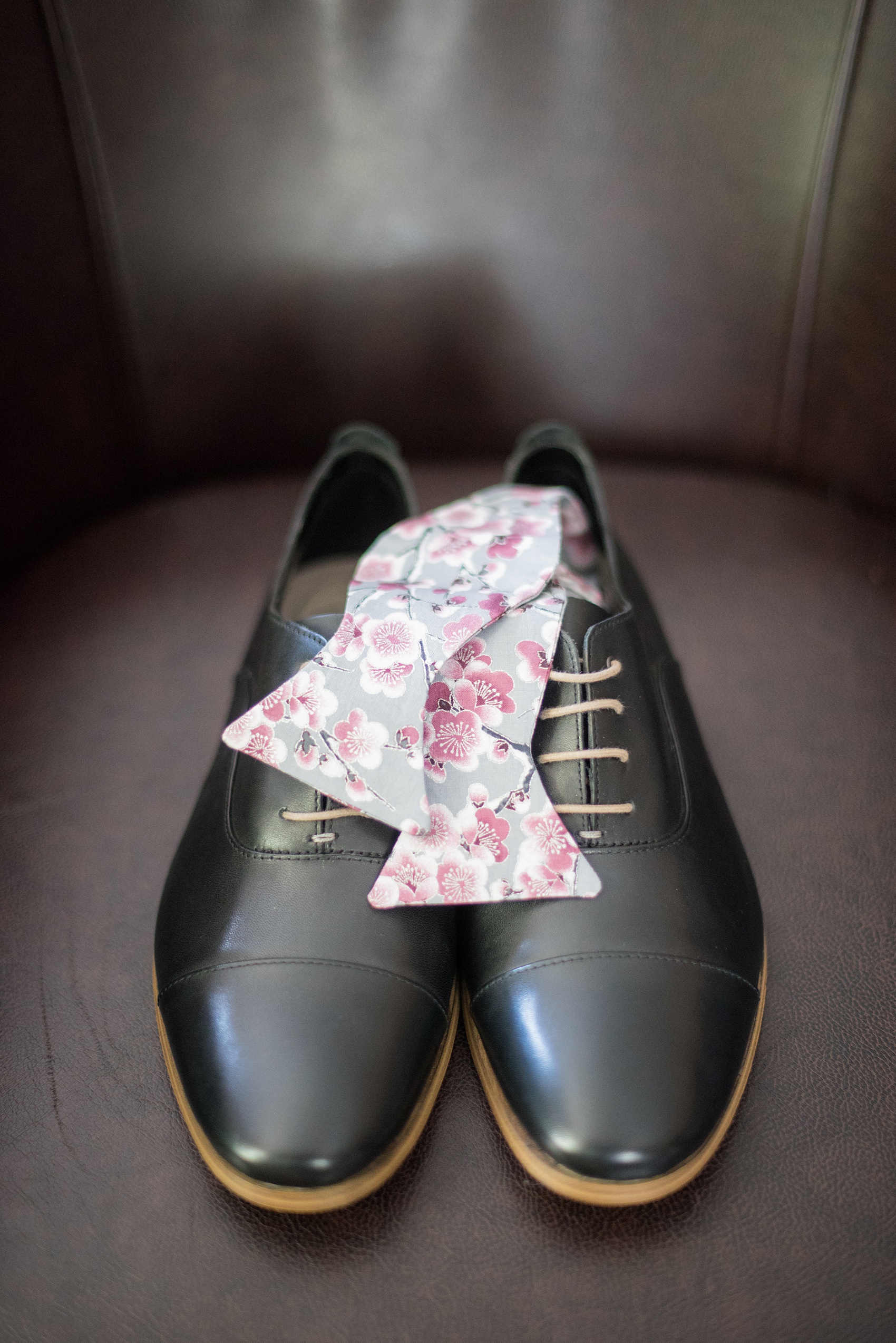 Mikkel Paige Photography photos of a wedding at Crabtree Kittle's House. Picture of the groom's black leather shoes and cherry blossom bow tie from Etsy. 