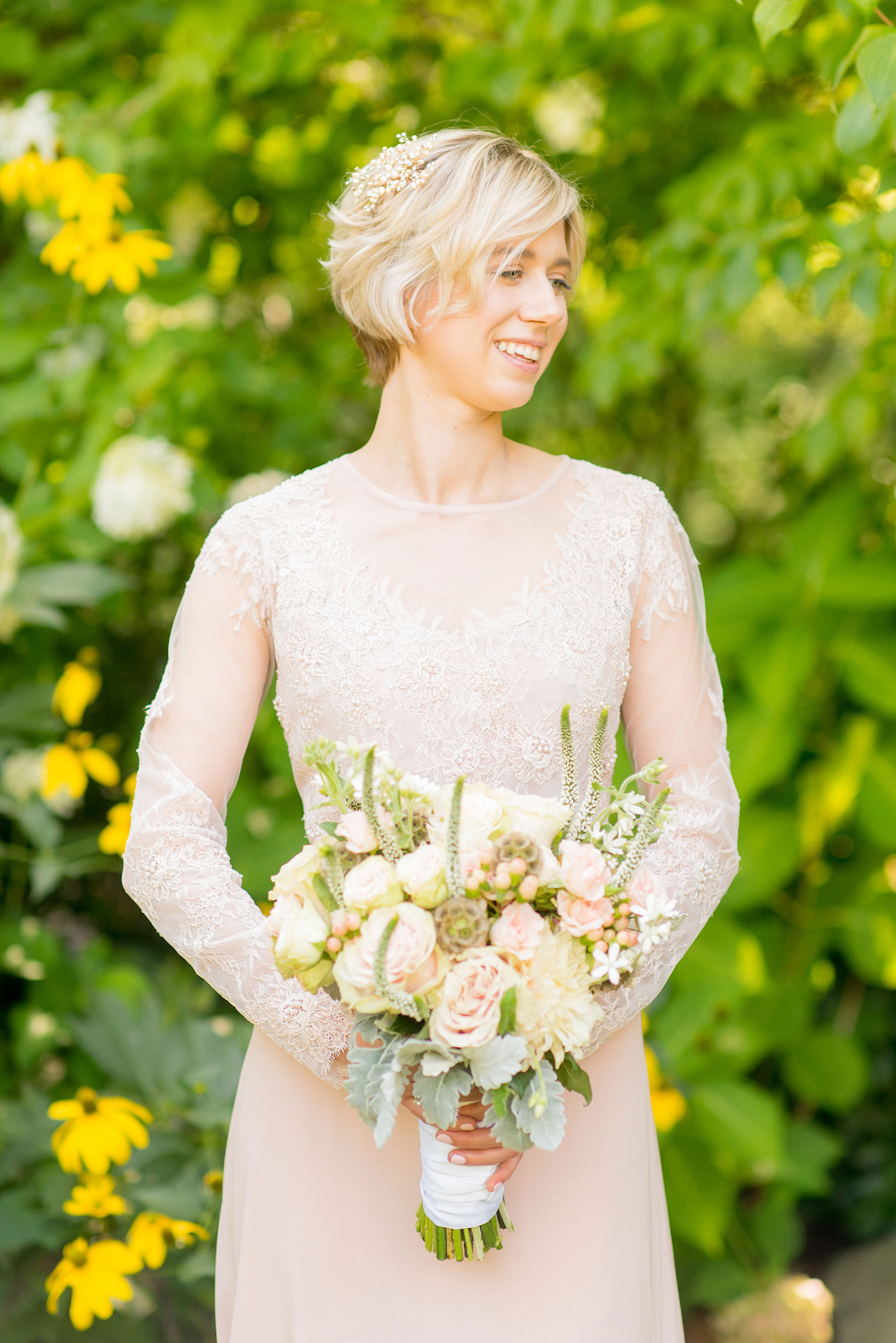 Mikkel Paige Photography photos of a wedding at Crabtree Kittle's House. Picture of the bride holding her flowers, in her blush lace beaded custom gown, smiling in the garden.