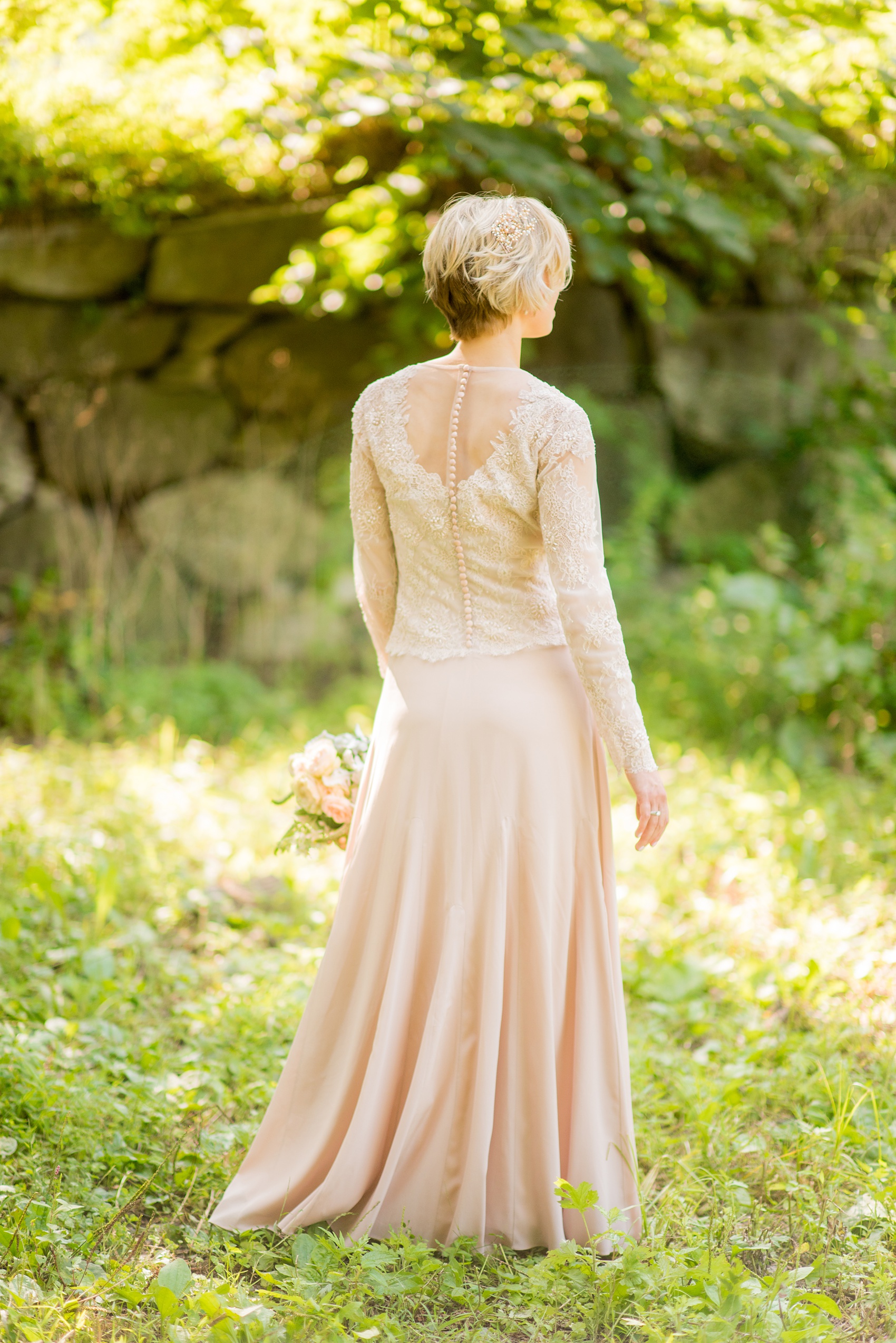 Mikkel Paige Photography photos of a wedding at Crabtree Kittle's House. Picture of the bride holding in her custom blush lace beaded gown.