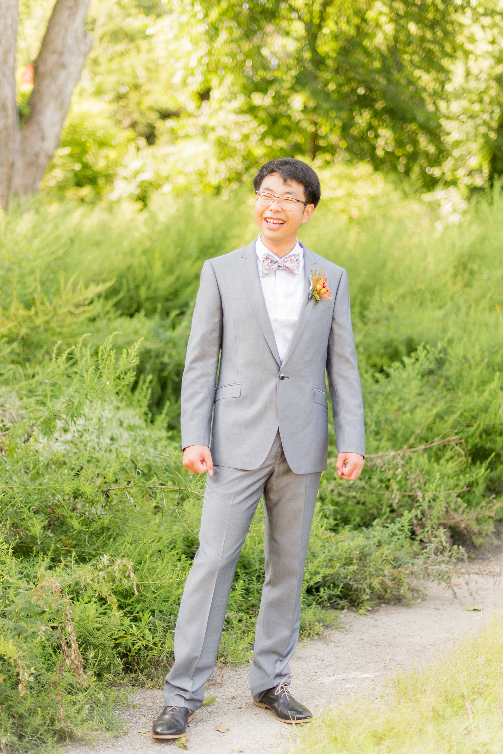 Mikkel Paige Photography photos of a wedding at Crabtree Kittle's House. Picture of the groom in his grey suit, cherry blossom pink bow tie, and orchid boutonniere.