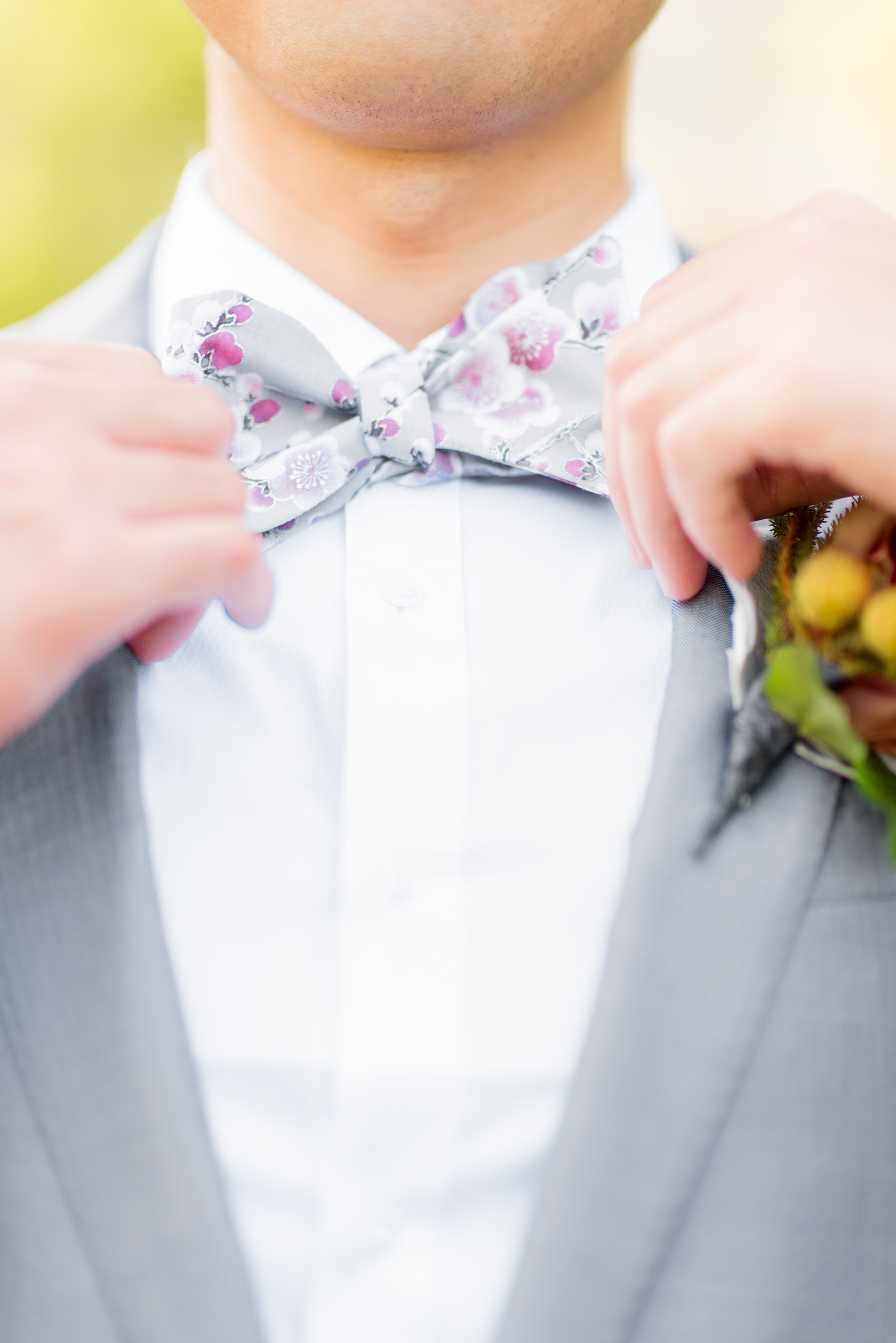 Mikkel Paige Photography photos of a wedding at Crabtree Kittle's House. Picture of the groom in his grey suit, cherry blossom pink bow tie, and orchid boutonniere.