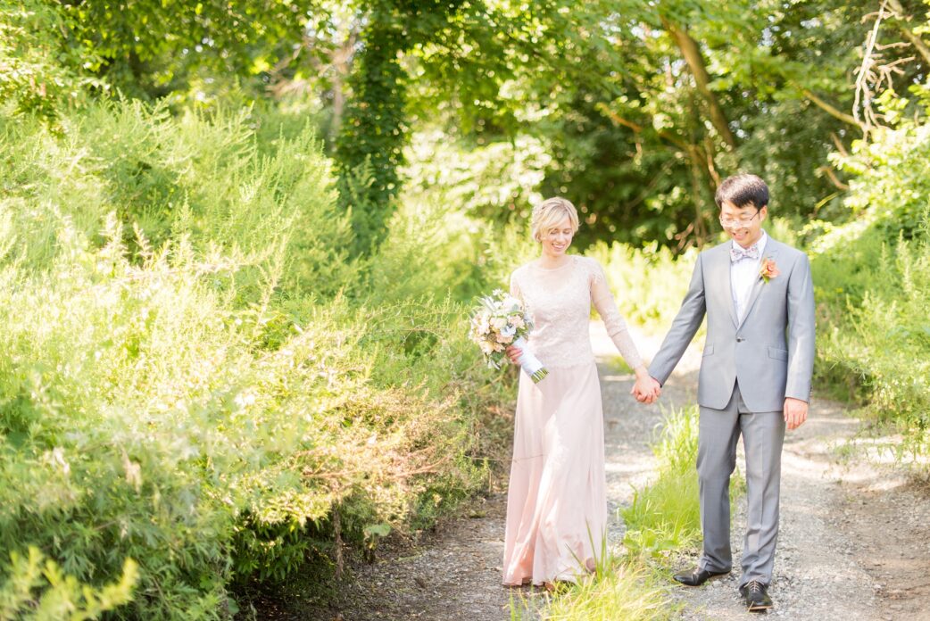 Mikkel Paige Photography photos of a wedding at Crabtree Kittle's House. Picture of the bride and groom in a grey suit and custom blush pink gown walking in the garden.