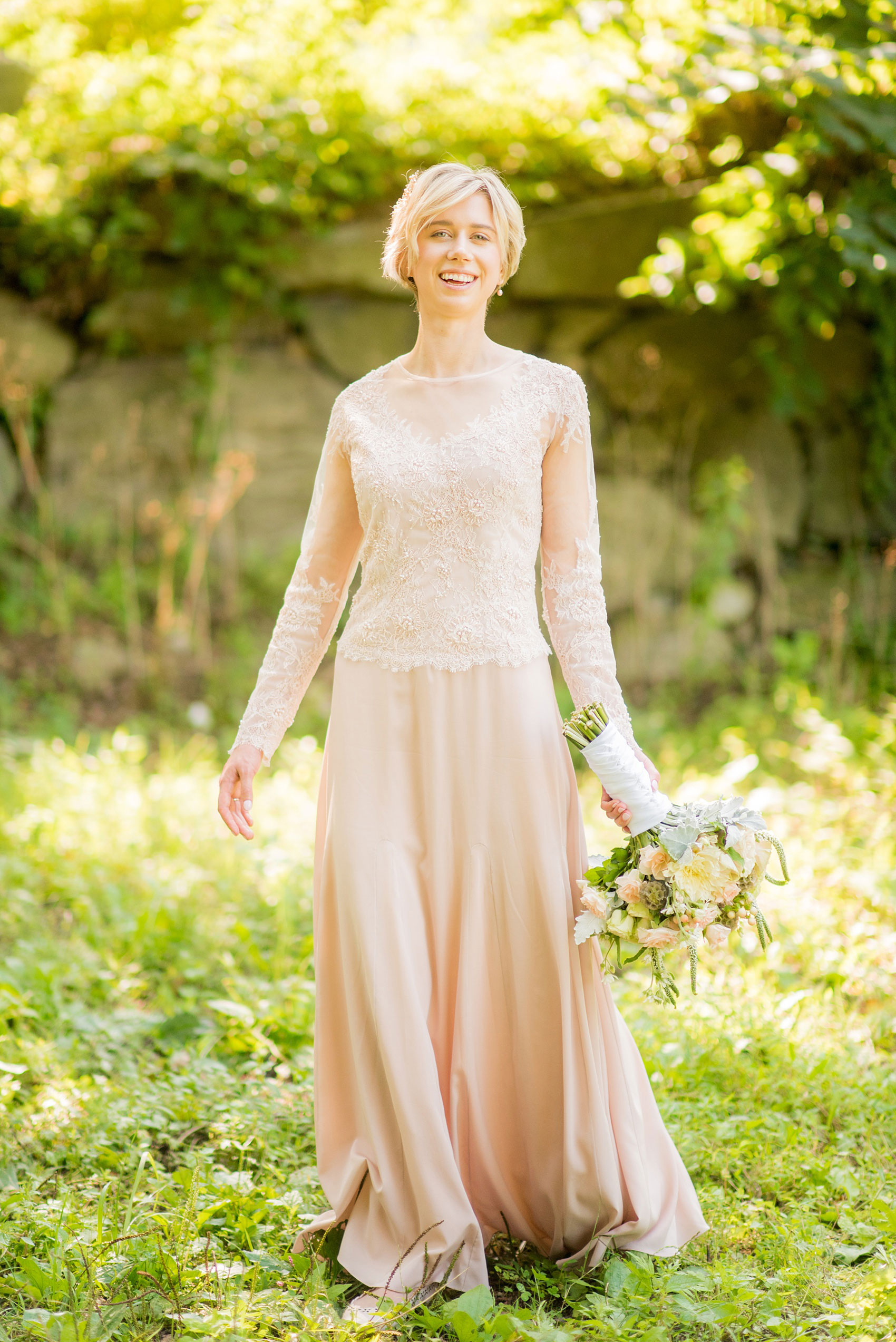 Mikkel Paige Photography photos of a wedding at Crabtree Kittle's House. Picture of the bride holding in her custom blush lace beaded gown.