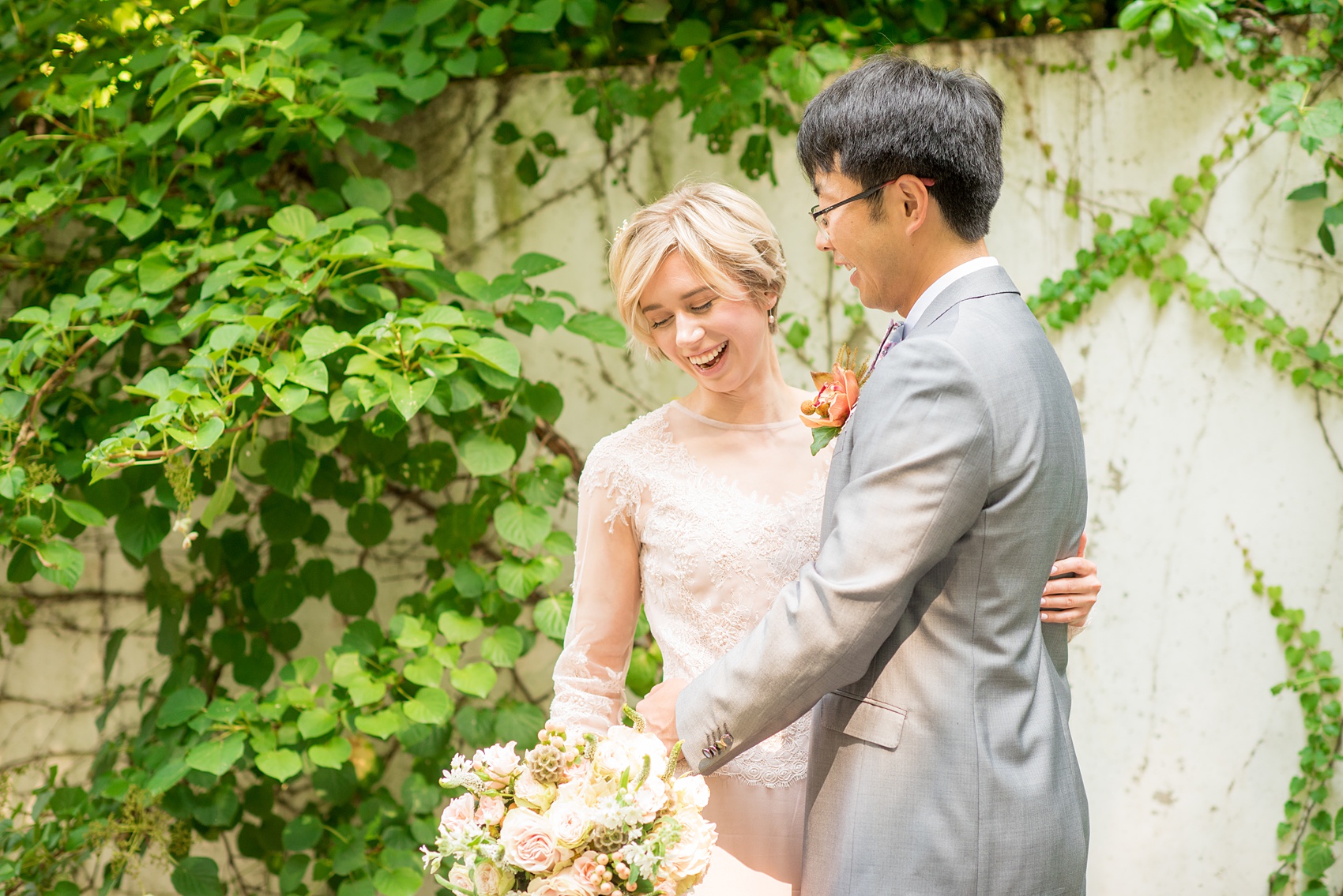 Mikkel Paige Photography photos of a wedding at Crabtree Kittle's House. Picture of the bride and groom smiling. He wore a grey suit and she wore a custom blush pink gown.