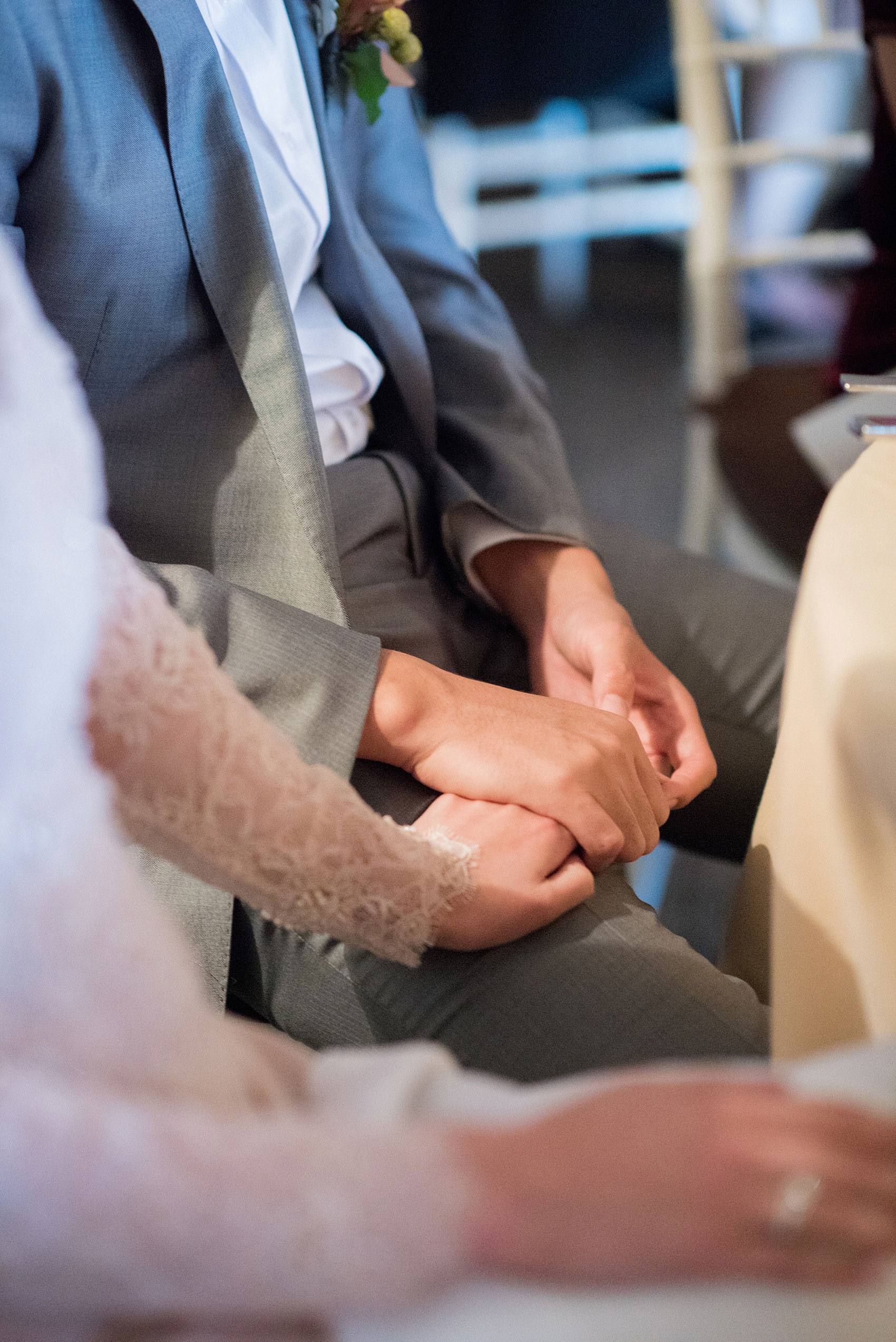 Mikkel Paige Photography photos of a wedding at Crabtree Kittle's House. Candid picture of the bride and groom holding hands during the reception speeches. 