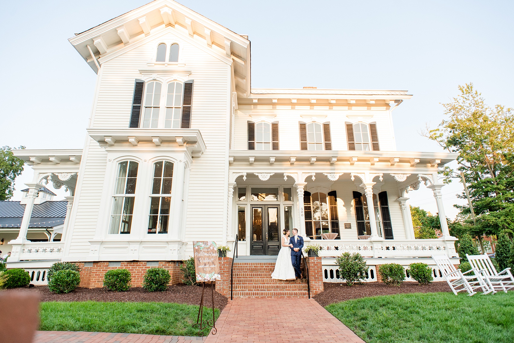 Mikkel Paige Photography pictures from a wedding at Merrimon-Wynne House in Raleigh, NC. Photo of the bride and groom in front if the historic home.