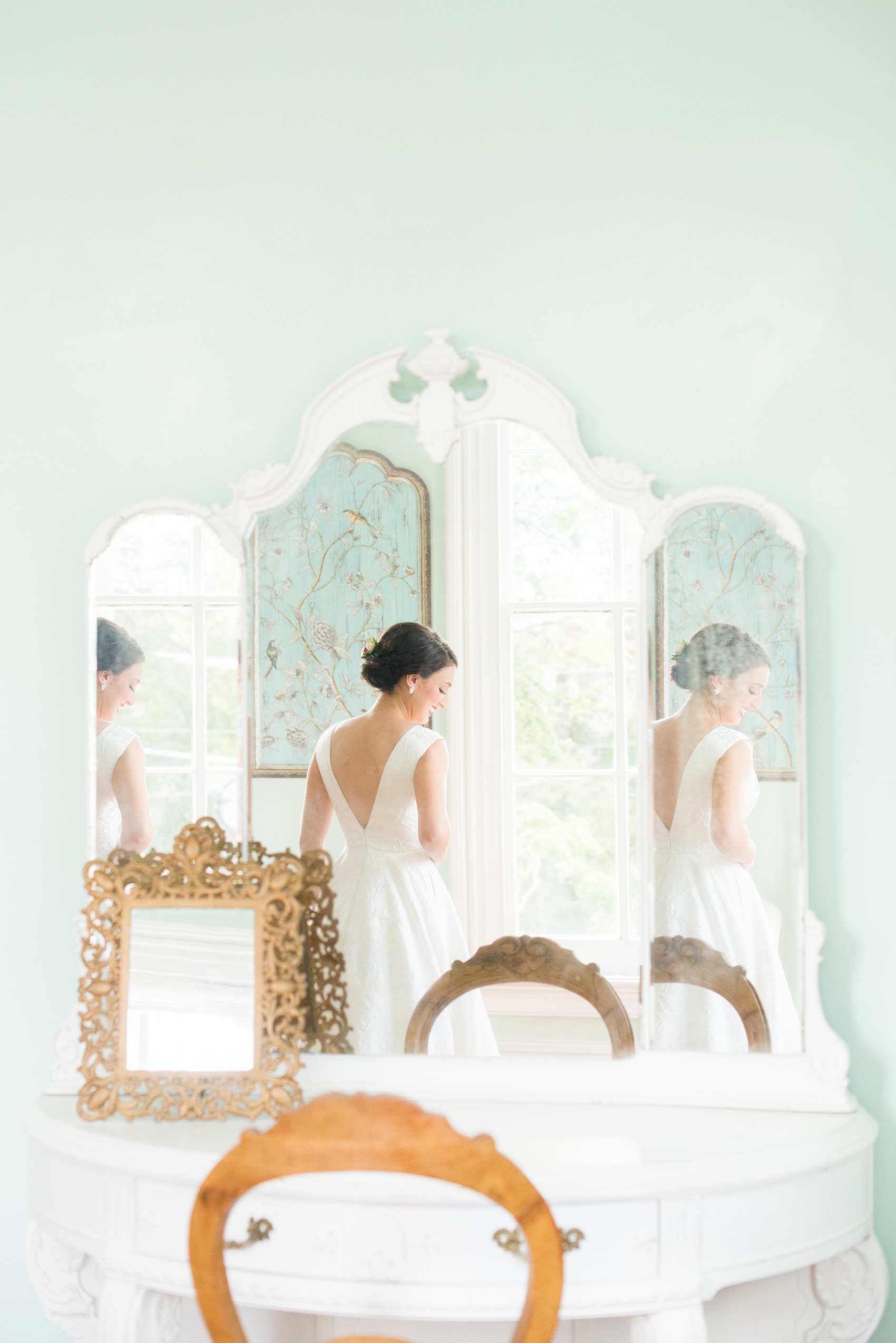 Mikkel Paige Photography pictures from a wedding at Merrimon-Wynne House in Raleigh, NC. Photo of the bride reflecting in a mirror in the bridal suite.