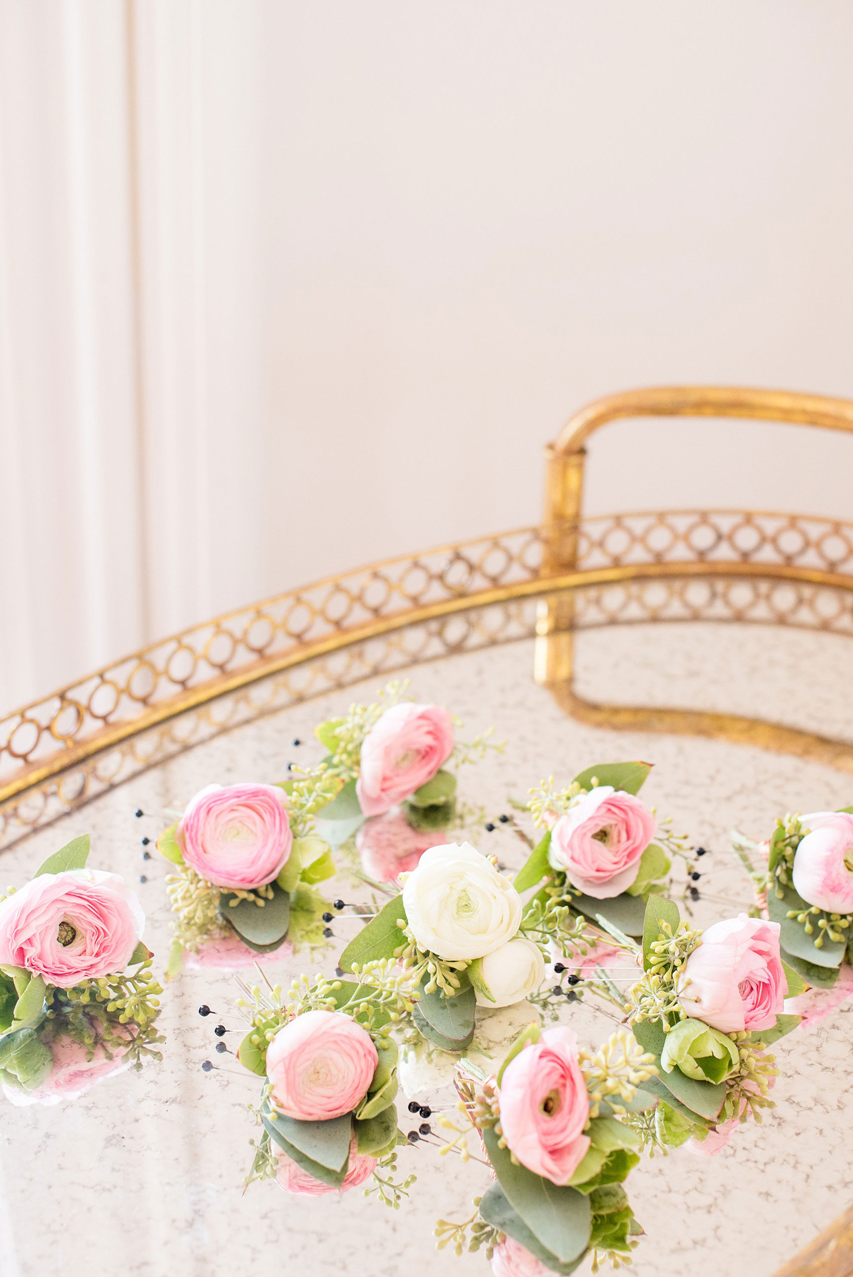 Mikkel Paige Photography pictures from a wedding at Merrimon-Wynne House in Raleigh, NC. Photo of white ranunculus boutonnieres with eucalyptus, tied with copper wire.