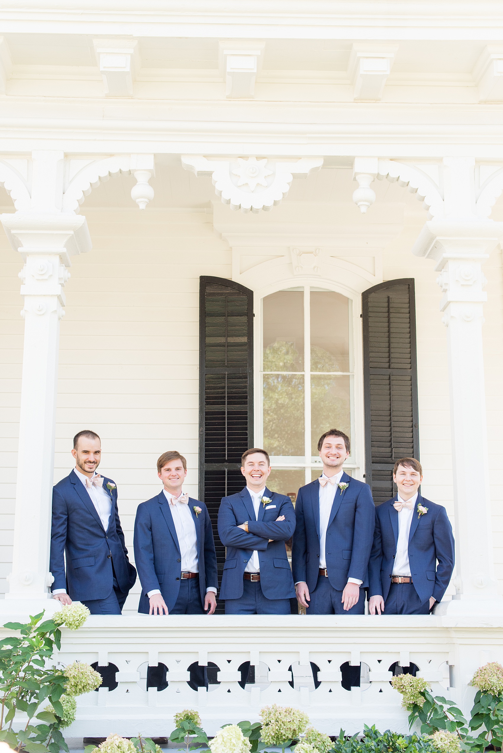 Mikkel Paige Photography pictures from a wedding at Merrimon-Wynne House in Raleigh, NC. Photo of the groomsmen in blue linen suits, pink boutonnieres tied with copper wire and pink bow ties.