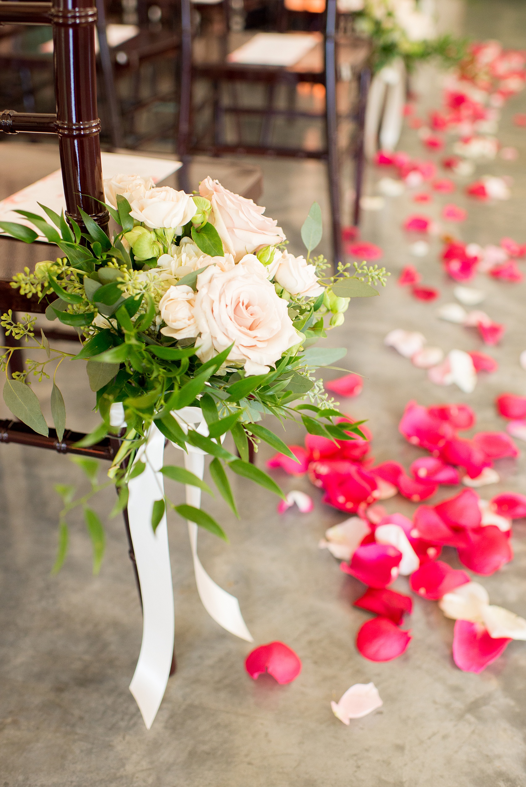 Mikkel Paige Photography pictures from a wedding at Merrimon-Wynne House in Raleigh, NC. Photo of the ceremony details including chair flowers and petals.