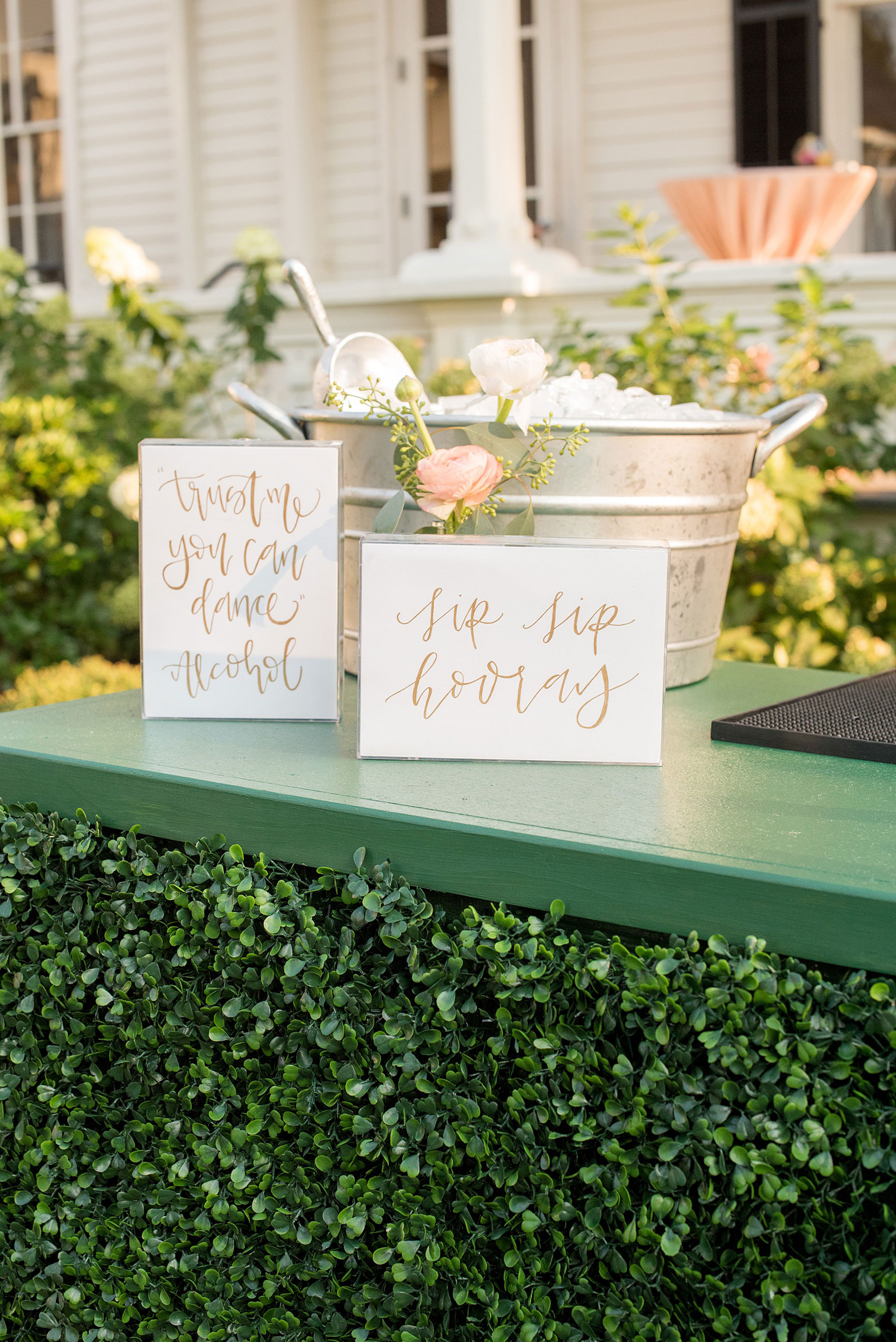 Mikkel Paige Photography pictures from a wedding at Merrimon-Wynne House in Raleigh, NC. Photo of the boxwood bar with script signage.