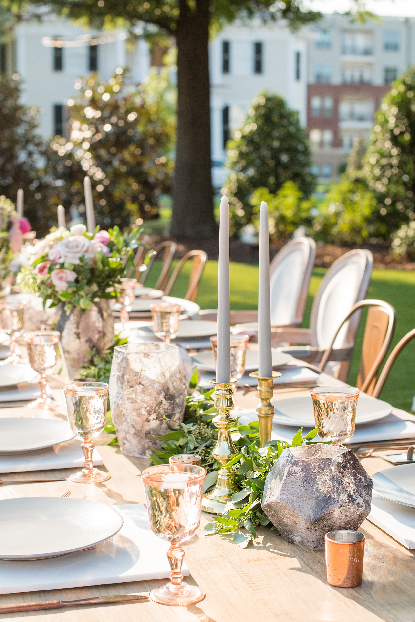 Mikkel Paige Photography pictures from a wedding at Merrimon-Wynne House in Raleigh, NC. Photo of the head dinner farm table with grey tapered candles, marble votive holders and colorful flowers.