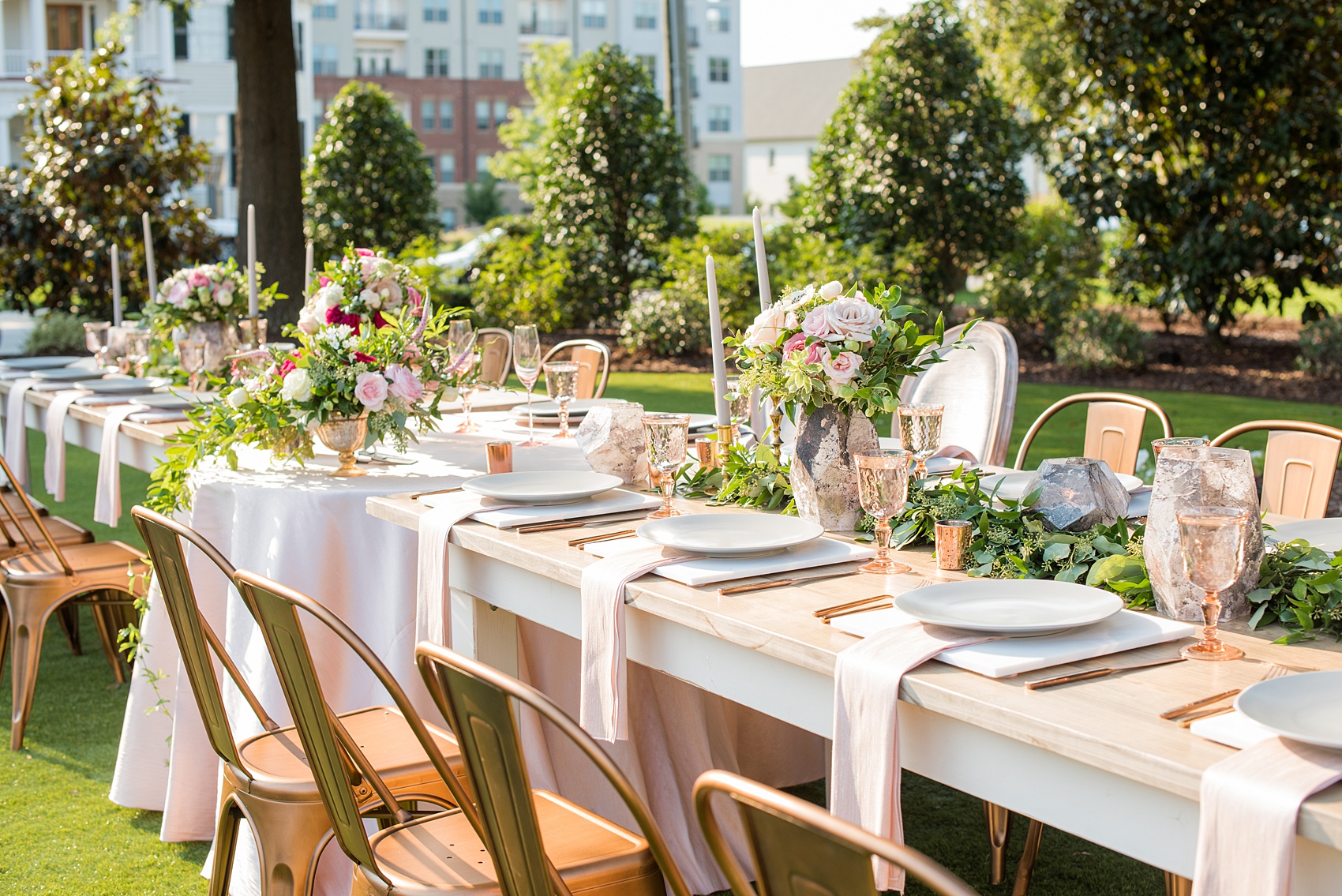 Mikkel Paige Photography pictures from a wedding at Merrimon-Wynne House in Raleigh, NC. Photo of the head dinner farm table with pink linen napkins, grey plates and marble chargers.