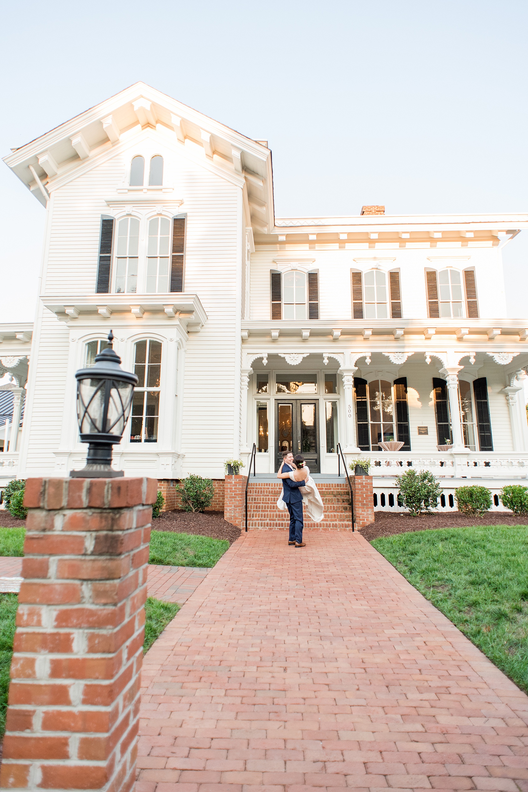 Mikkel Paige Photography pictures from a wedding at Merrimon-Wynne House in Raleigh, NC. Photo of the bride and groom in front of the historic home.