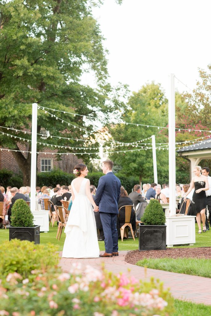 Mikkel Paige Photography pictures from a wedding at Merrimon-Wynne House in Raleigh, NC. Photo of the bride and groom joining their outdoor reception dinner.