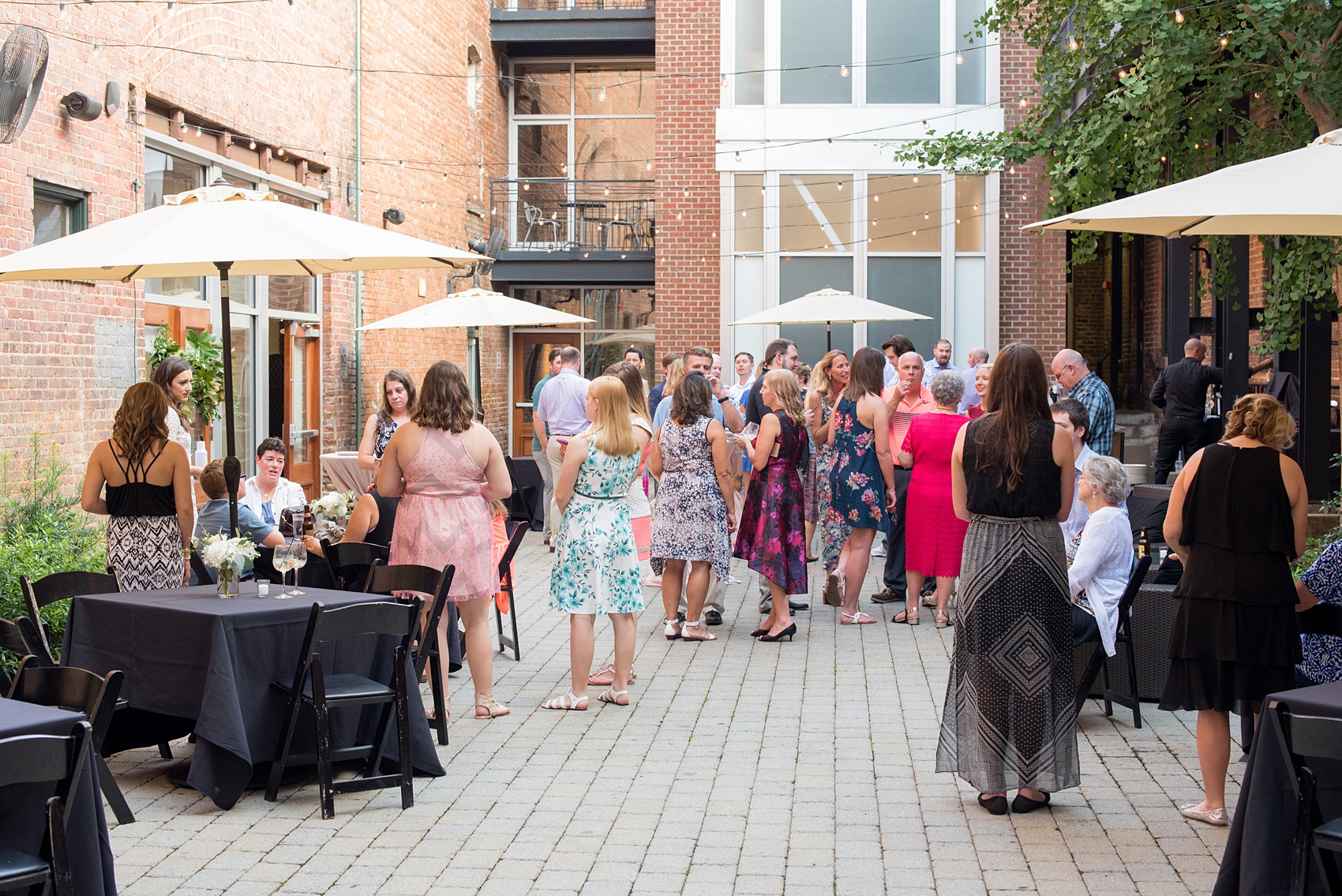 Mikkel Paige Photography photos from a downtown Raleigh wedding rehearsal dinner at Sitti restaurant. Picture of the guests enjoying the outdoor courtyard.