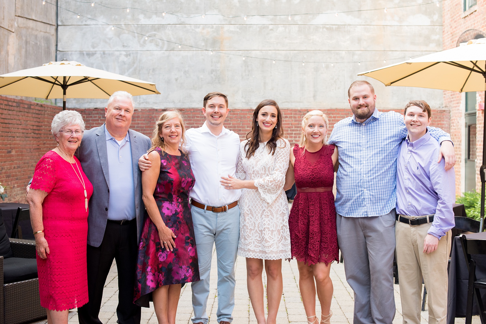 Mikkel Paige Photography photos from a downtown Raleigh wedding rehearsal dinner at Sitti restaurant. Picture of the bride and groom with their family.