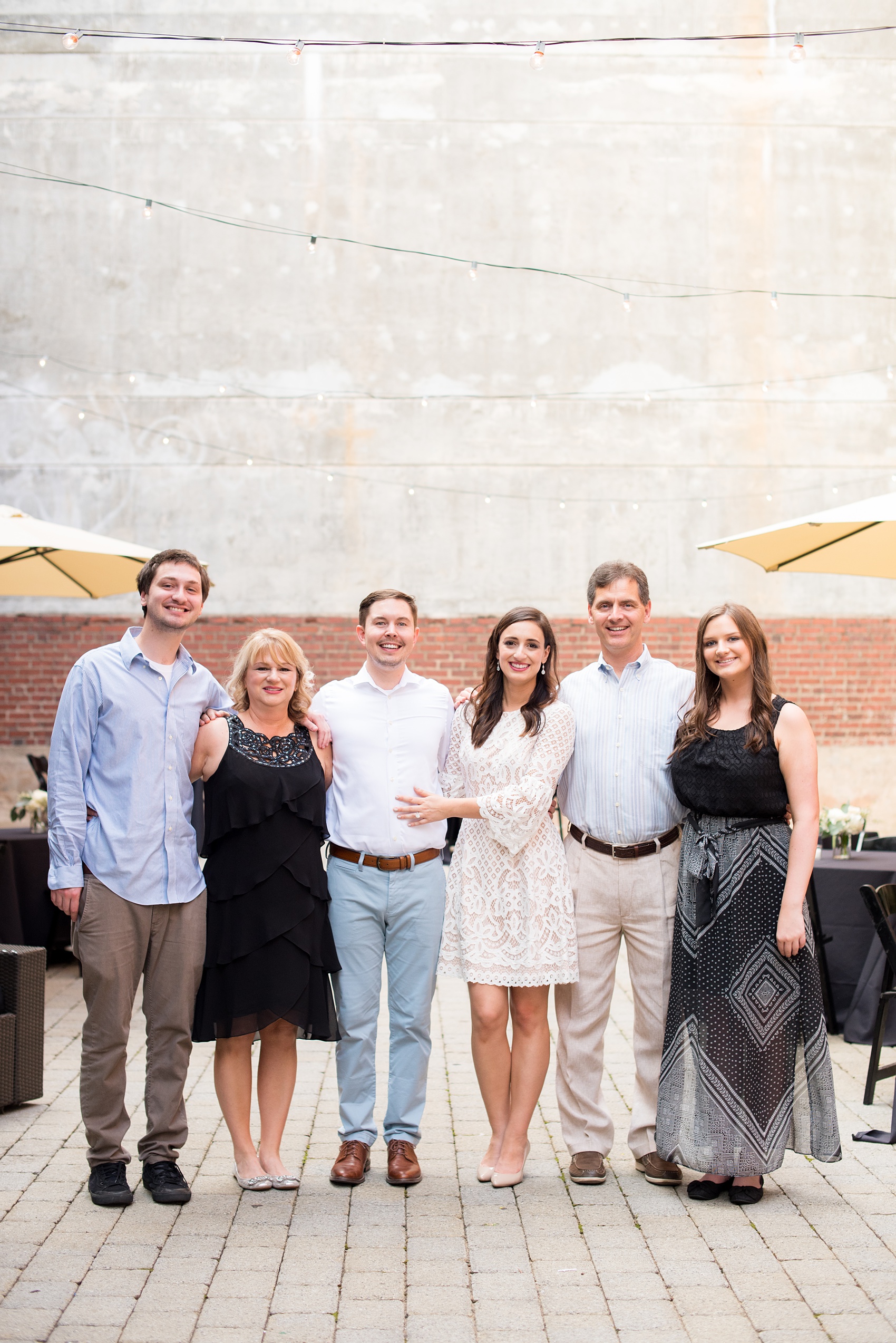 Mikkel Paige Photography photos from a downtown Raleigh wedding rehearsal dinner at Sitti restaurant. Picture of the bride and groom with their family.