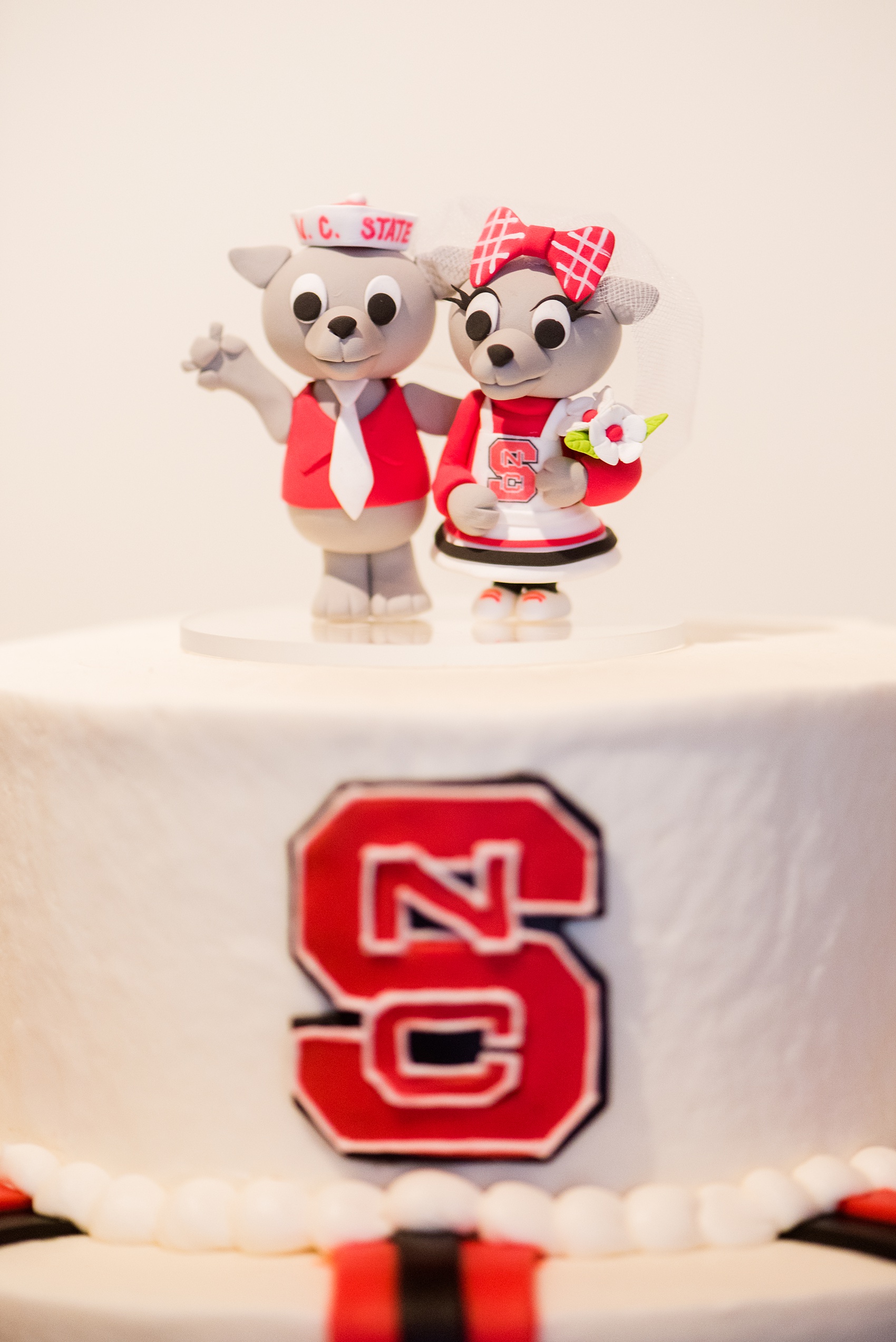Mikkel Paige Photography photos from a downtown Raleigh wedding rehearsal dinner at Sitti restaurant. Detail photo of the NC State groom's cake topper.