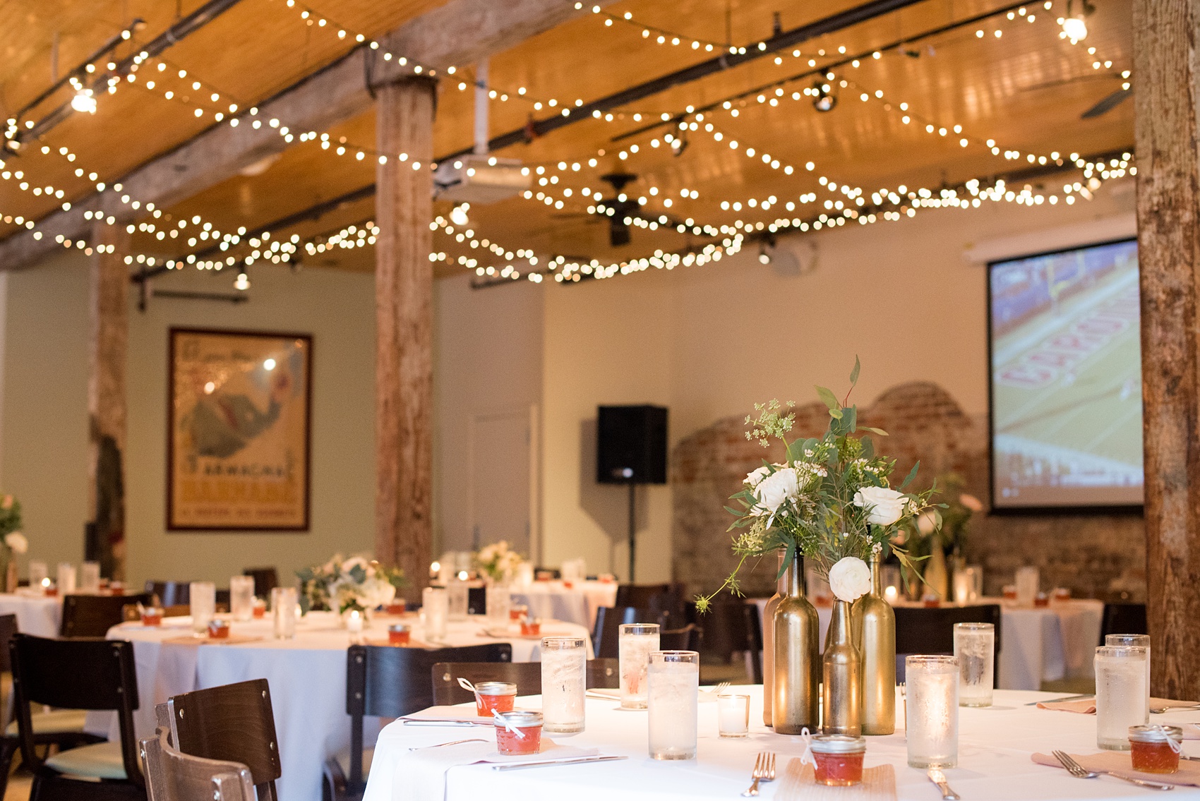 Mikkel Paige Photography photos from a downtown Raleigh wedding rehearsal dinner at Sitti restaurant. Photo of the inside seated dinner with candlelight, twinkle lights, floral centerpieces and jam guest favors.