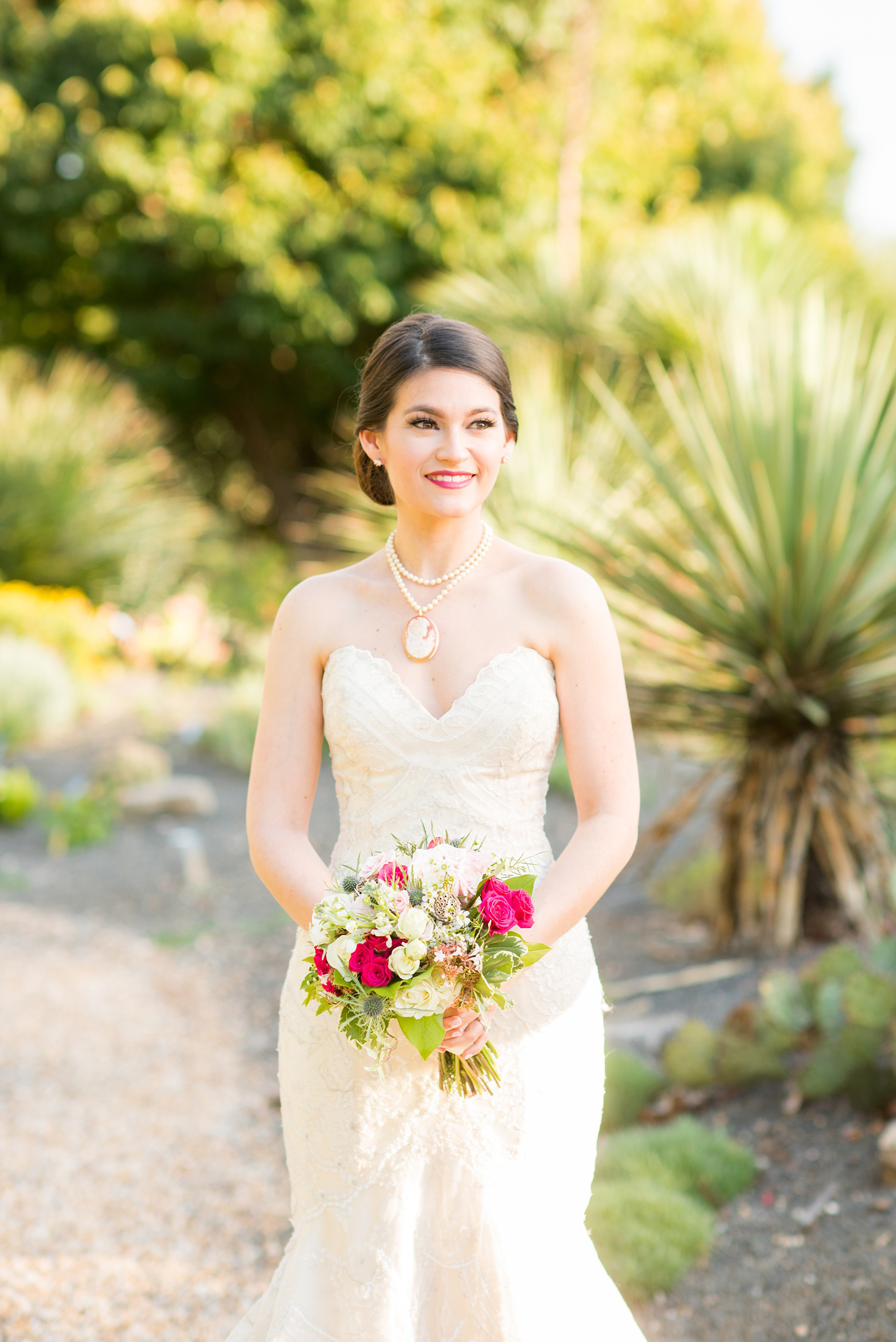 Mikkel Paige Photography photos from a bridal session at Raleigh's JC Raulston Arboretum on North Carolina's NC State campus. The bride wore an off-white vintage lace gown with a cameo and pearl necklace.