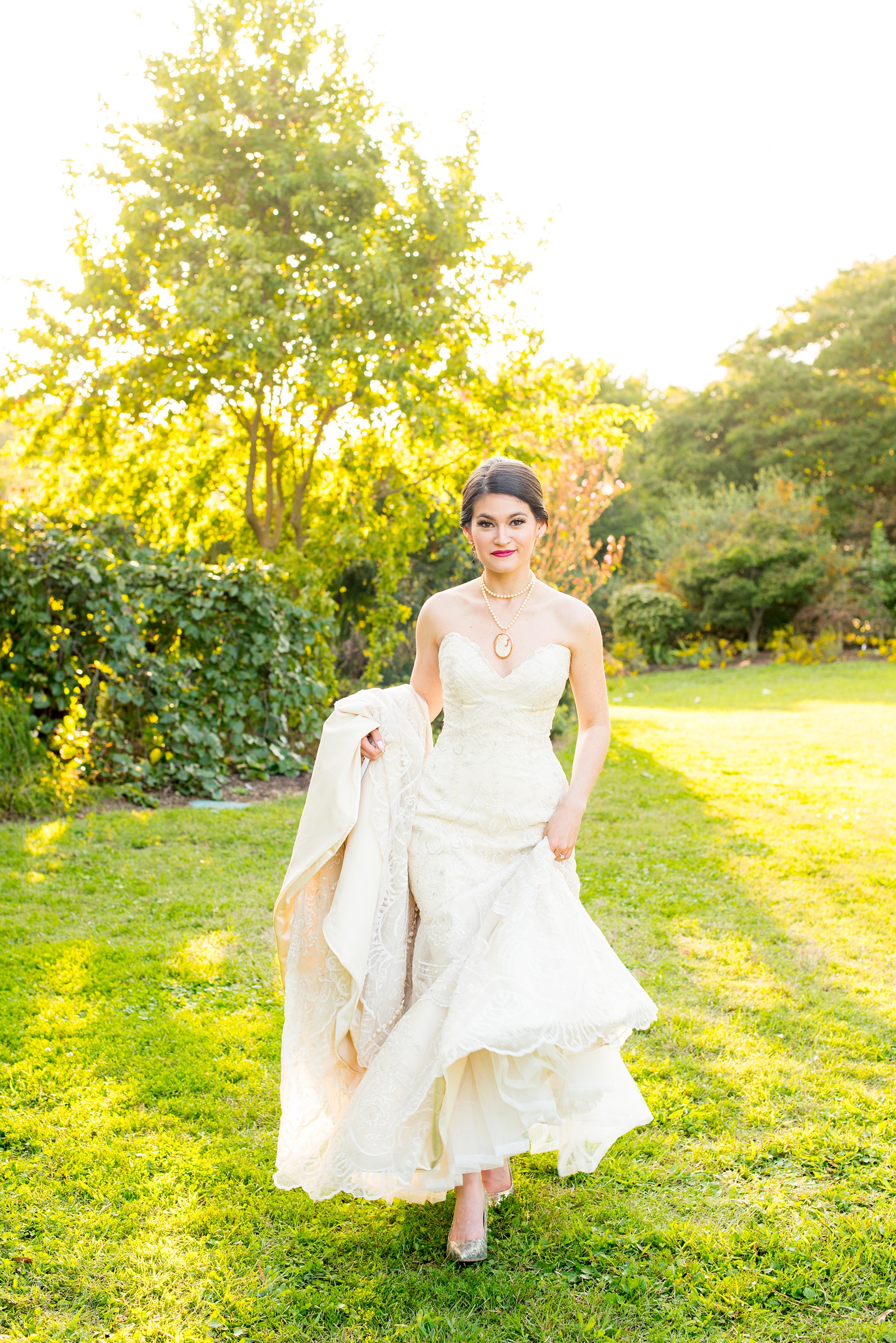 Mikkel Paige Photography photos from a bridal session at Raleigh's JC Raulston Arboretum on North Carolina's NC State campus. Picture of the bride walking in her strapless lace gown.