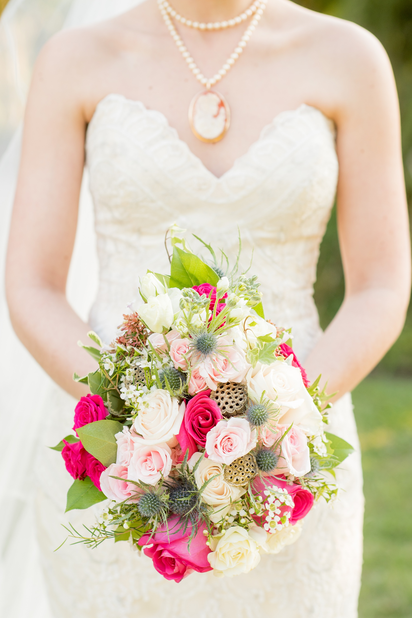 Mikkel Paige Photography photos from a bridal session at Raleigh's JC Raulston Arboretum on North Carolina's NC State campus. Detail picture of the bride's bouquet with gold lily pods, blue thistle and spray roses.