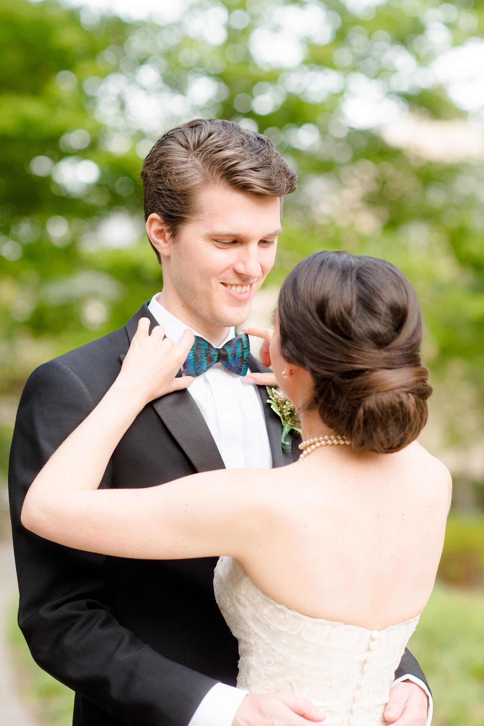 Mikkel Paige Photography photos from a wedding at Duke Chapel in North Carolina. Picture of the bride fixing the groom's bow tie.