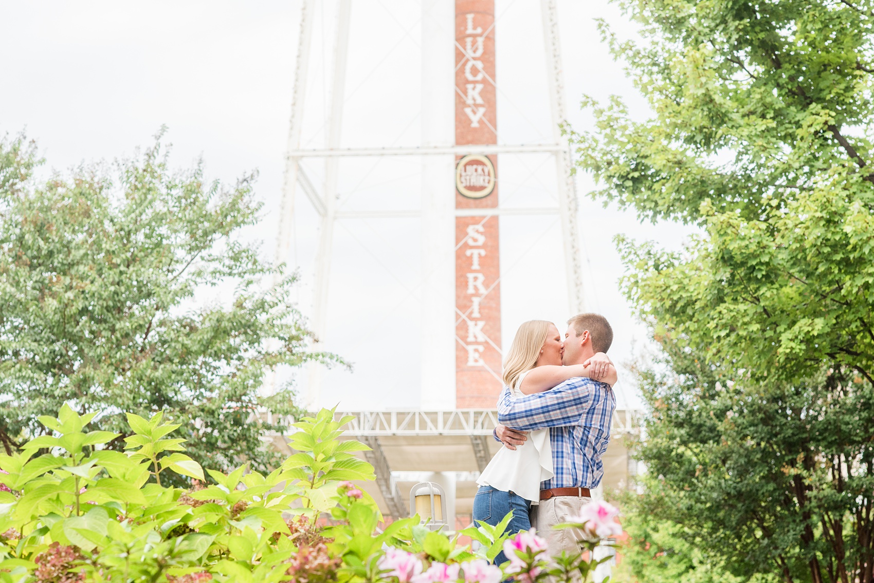 Mikkel Paige Photography photos from an engagement session at Durham's American Tobacco Campus in North Carolina. Picture of the couple with a "Lucky Strike" stack.