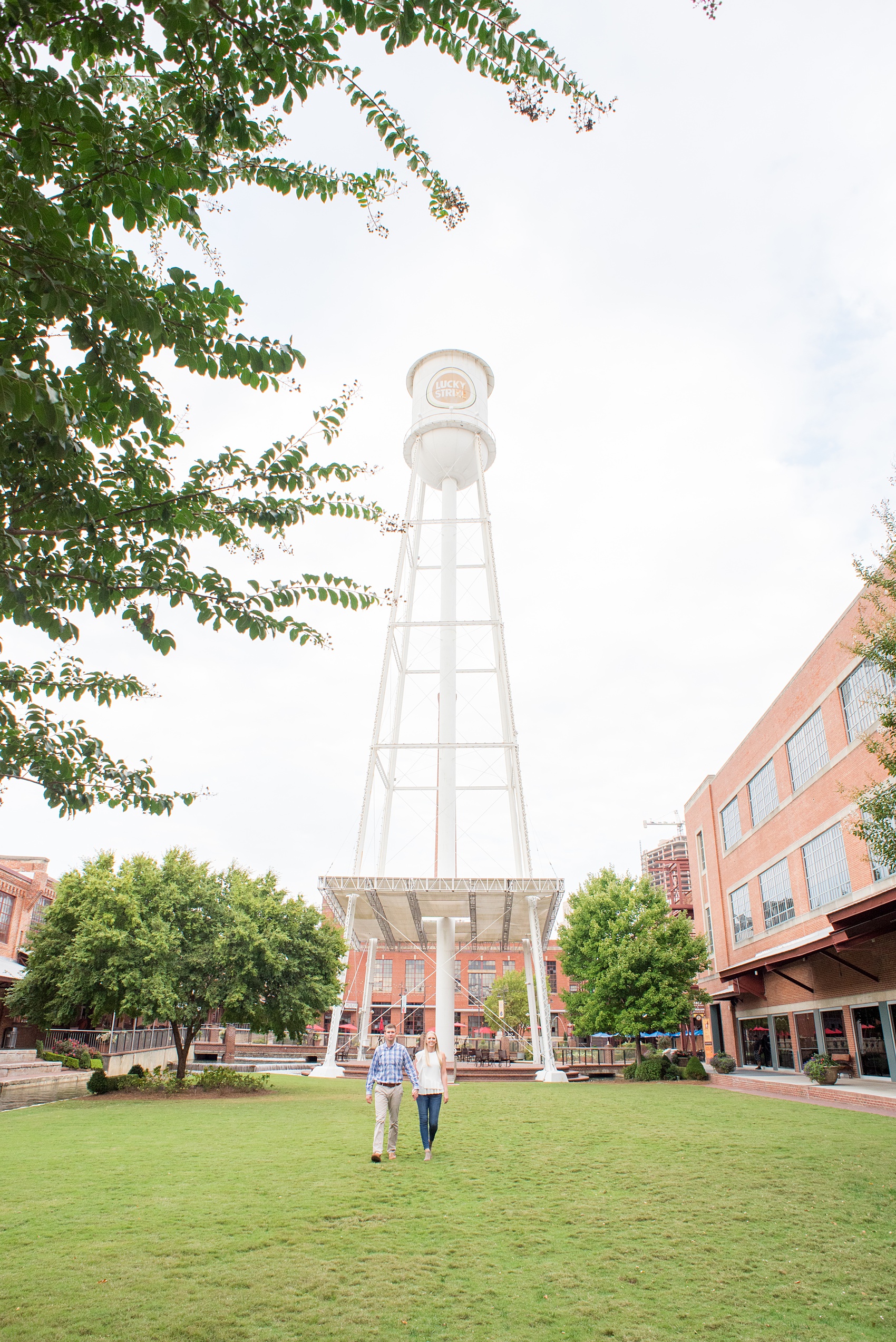 Mikkel Paige Photography photos from an engagement session at Durham's American Tobacco Campus in North Carolina. Picture of the couple near the city's iconic water tower.