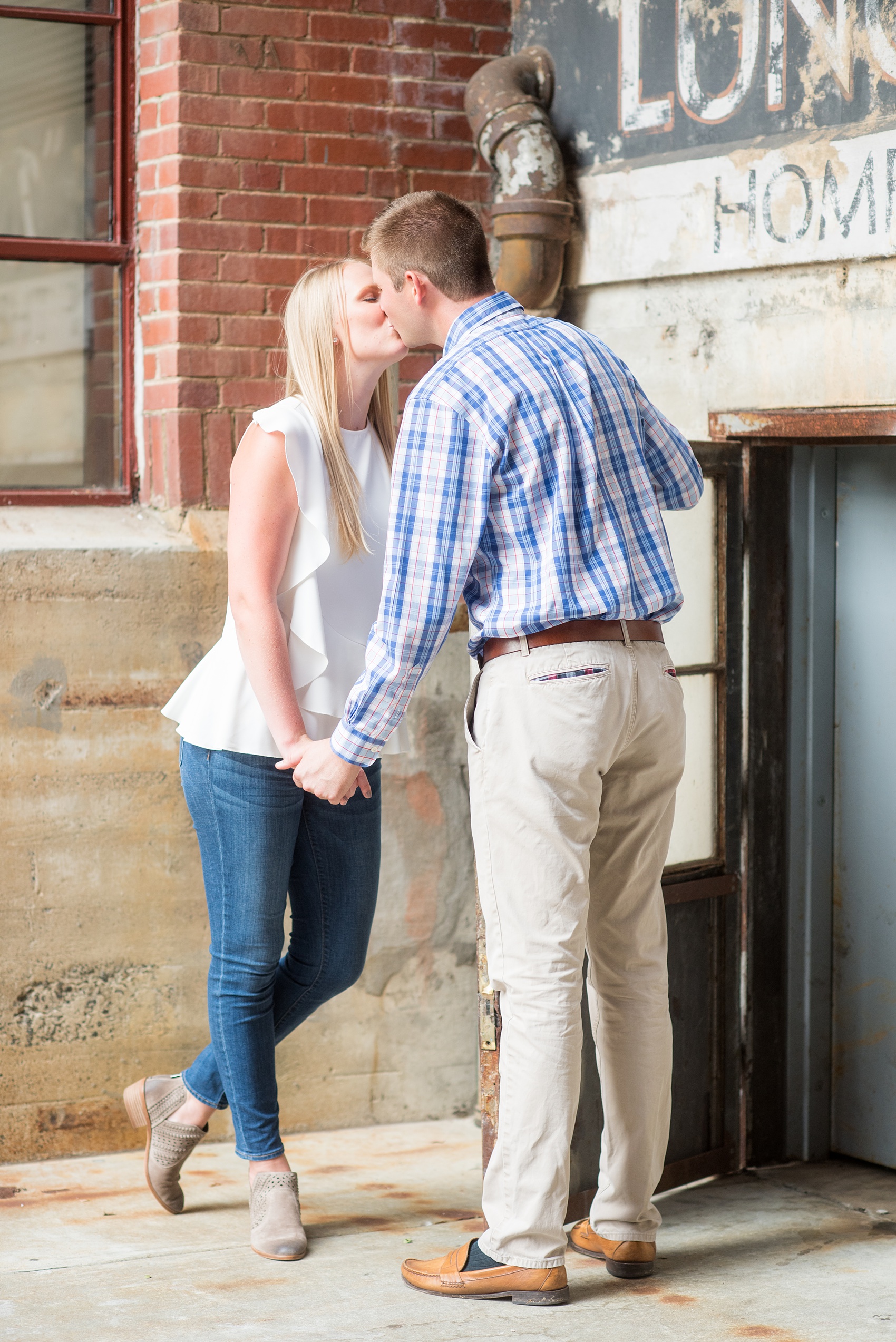 Mikkel Paige Photography photos from an engagement session at Durham's American Tobacco Campus in North Carolina. Sweet photo of the couple kissing.