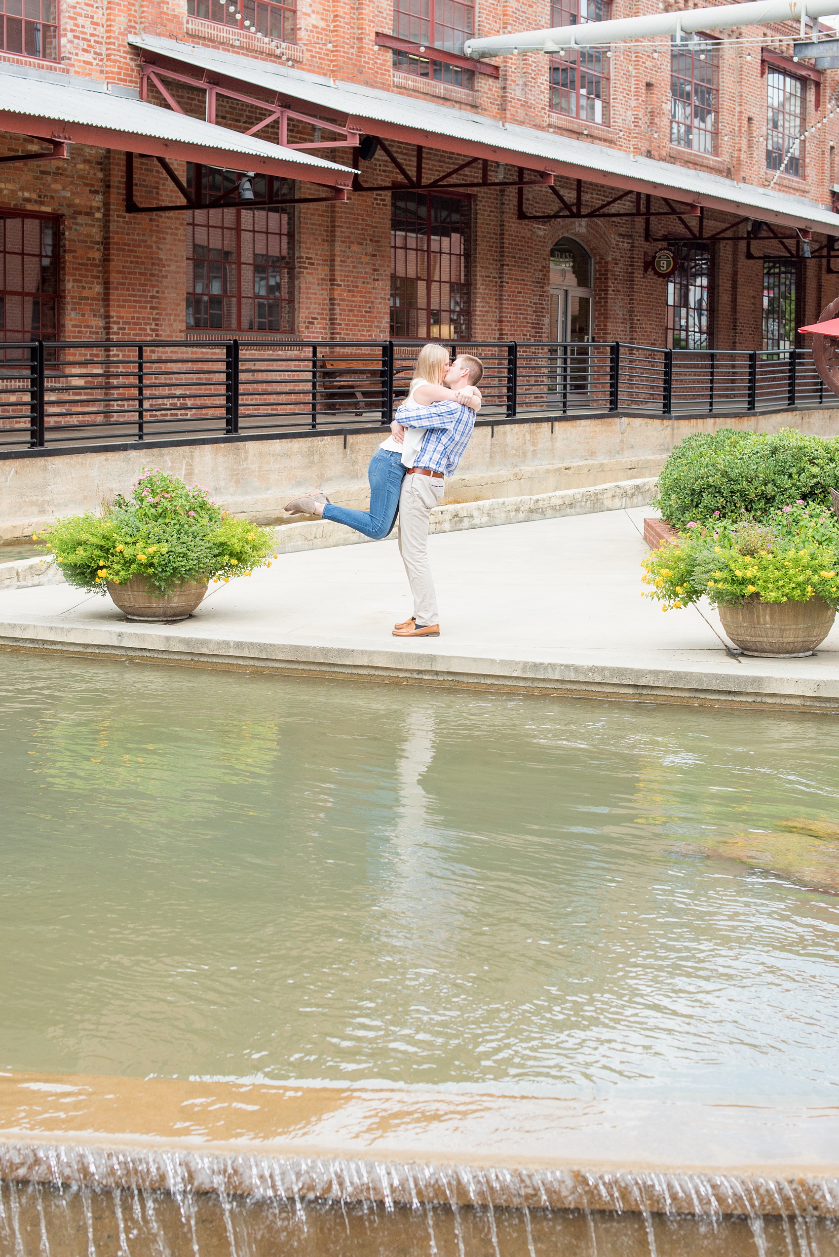 Mikkel Paige Photography photos from an engagement session at Durham's American Tobacco Campus in North Carolina. Photo of the couple near water on the property near Bay 7.