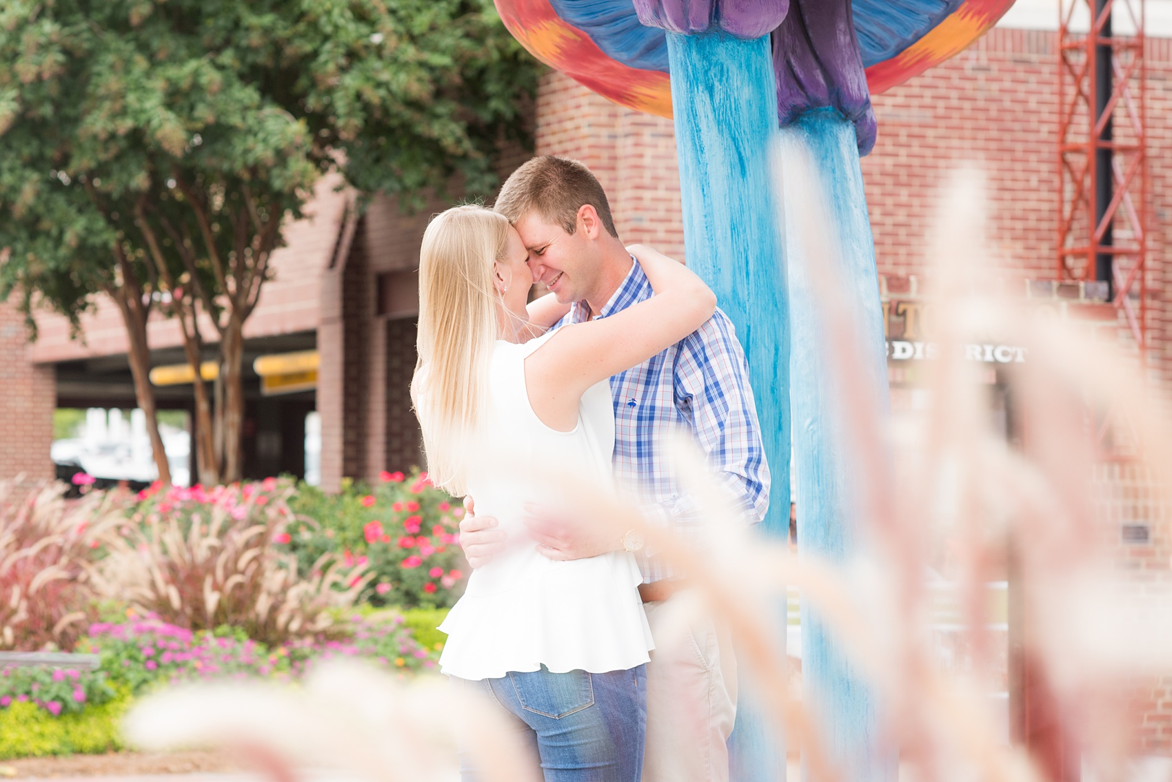 Mikkel Paige Photography photos from an engagement session at Durham's American Tobacco Campus in North Carolina. Colorful picture with the couple embracing.