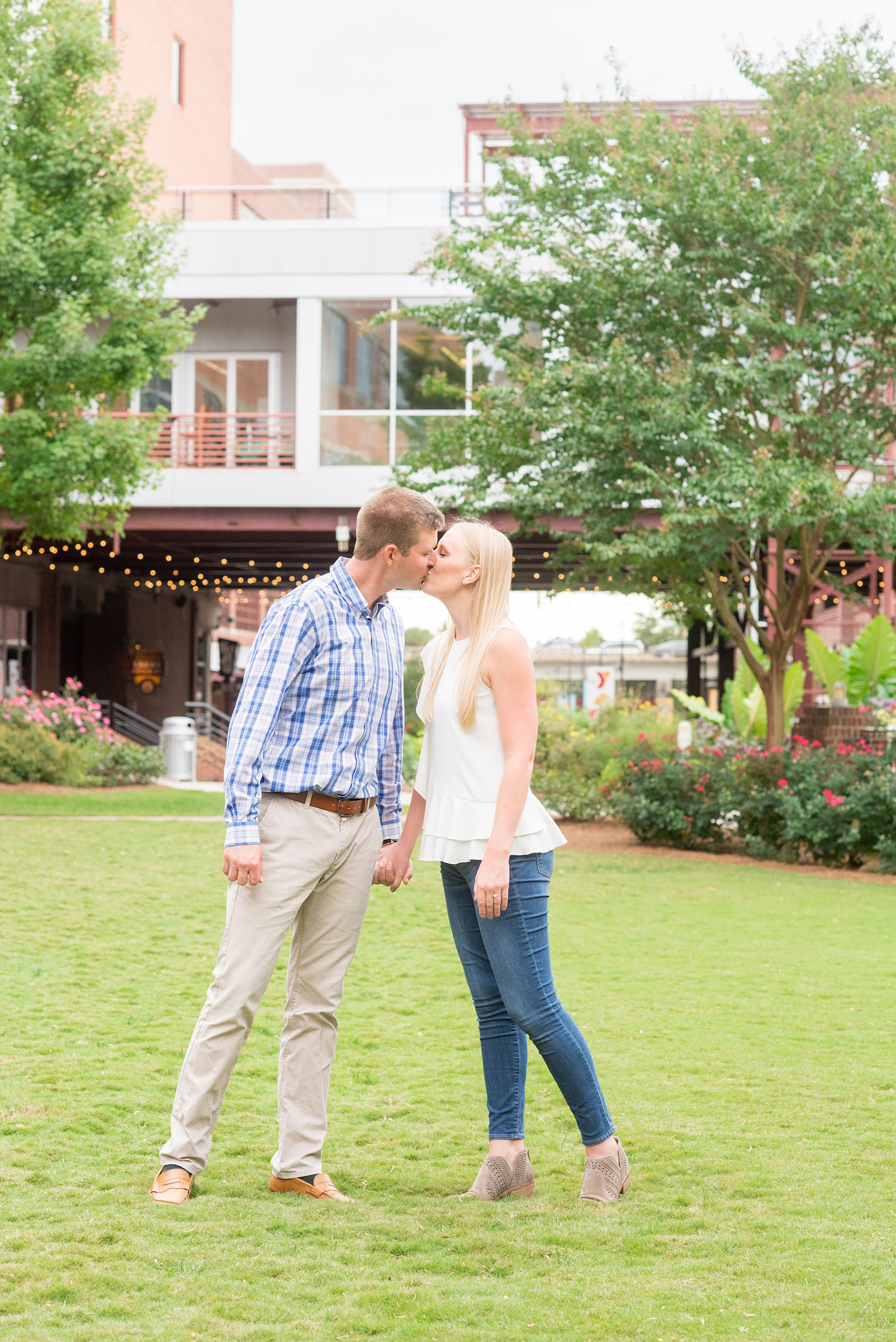 Mikkel Paige Photography photos from an engagement session at Durham's American Tobacco Campus in North Carolina. Photo of the couple on the colorfully landscaped site near Bay 7.