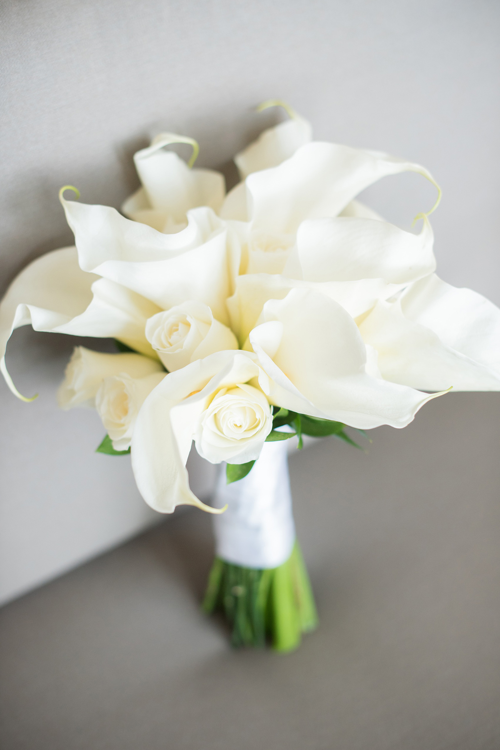 Mikkel Paige Photography photos from a wedding at Grand Paraiso, Mexico, Playa del Carmen Iberostar resort. Picture of the bride's calla lily and rose white bouquet. 