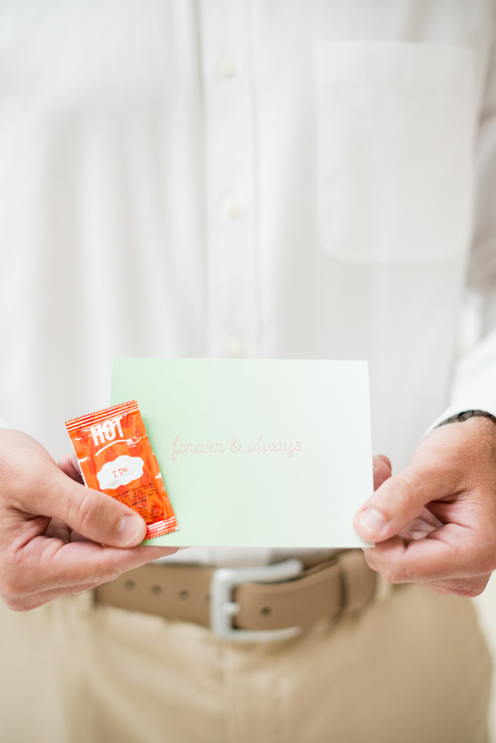 Mikkel Paige Photography photos from a wedding at Grand Paraiso, Mexico, Playa del Carmen Iberostar resort. Picture of the groom reading a letter form his bride and an "I Do" hot sauce packet.