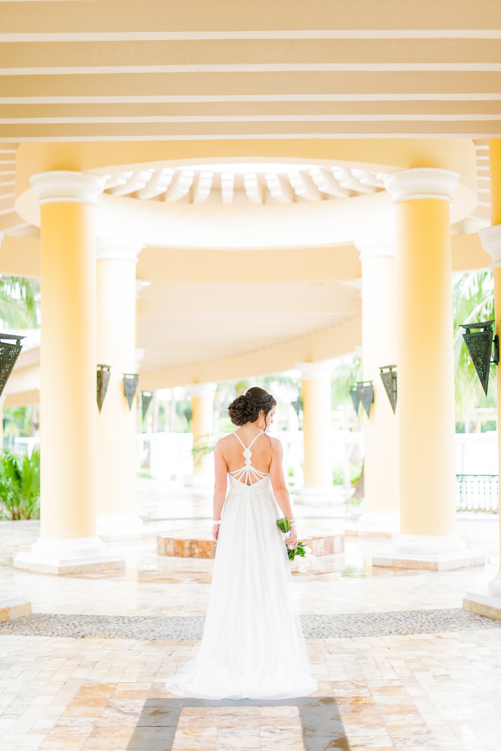 Mikkel Paige Photography photos from a wedding at Grand Paraiso, Mexico, Playa del Carmen Iberostar resort. Picture of the back of the bride's beach dress with string detail.