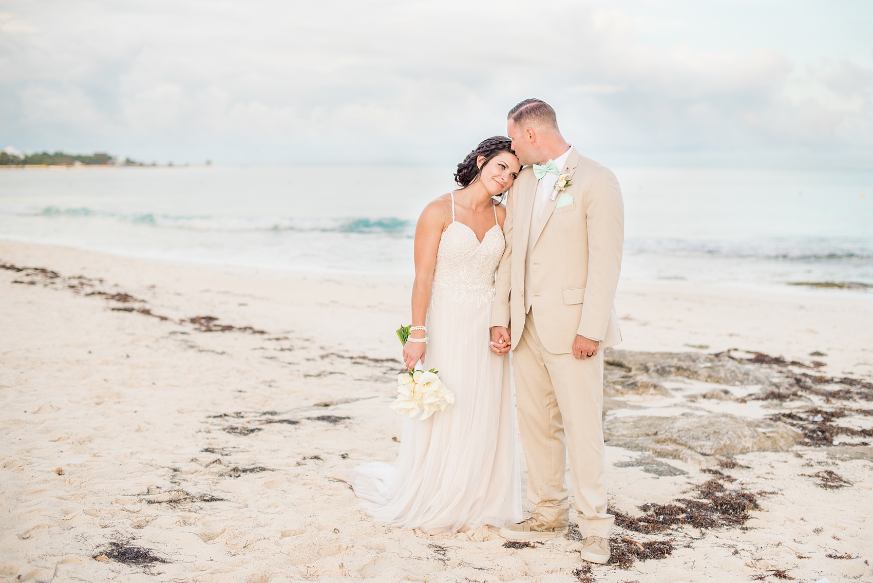 Mikkel Paige Photography photos from a wedding at Grand Paraiso, Mexico, Playa del Carmen Iberostar resort. Picture of the bride and groom on the sand of the beach.