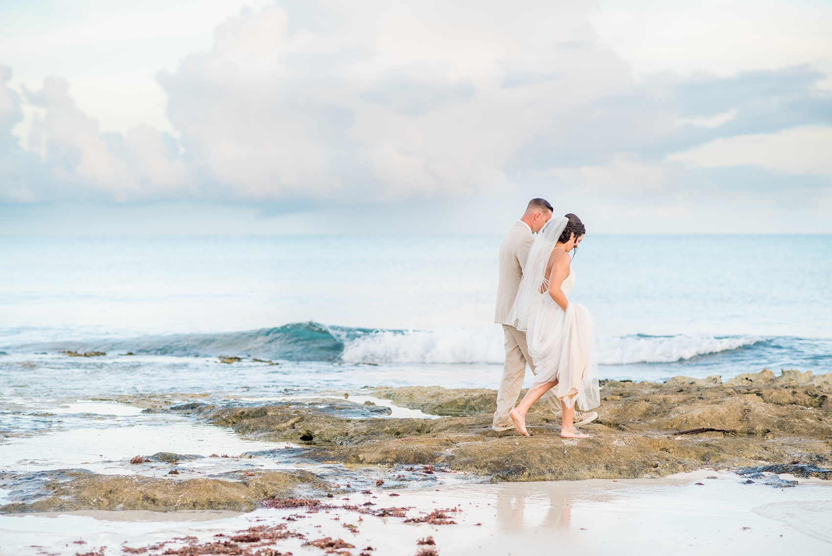 Mikkel Paige Photography photos from a wedding at Grand Paraiso, Mexico, Playa del Carmen Iberostar resort. Picture of the bride and groom walking on the beach.