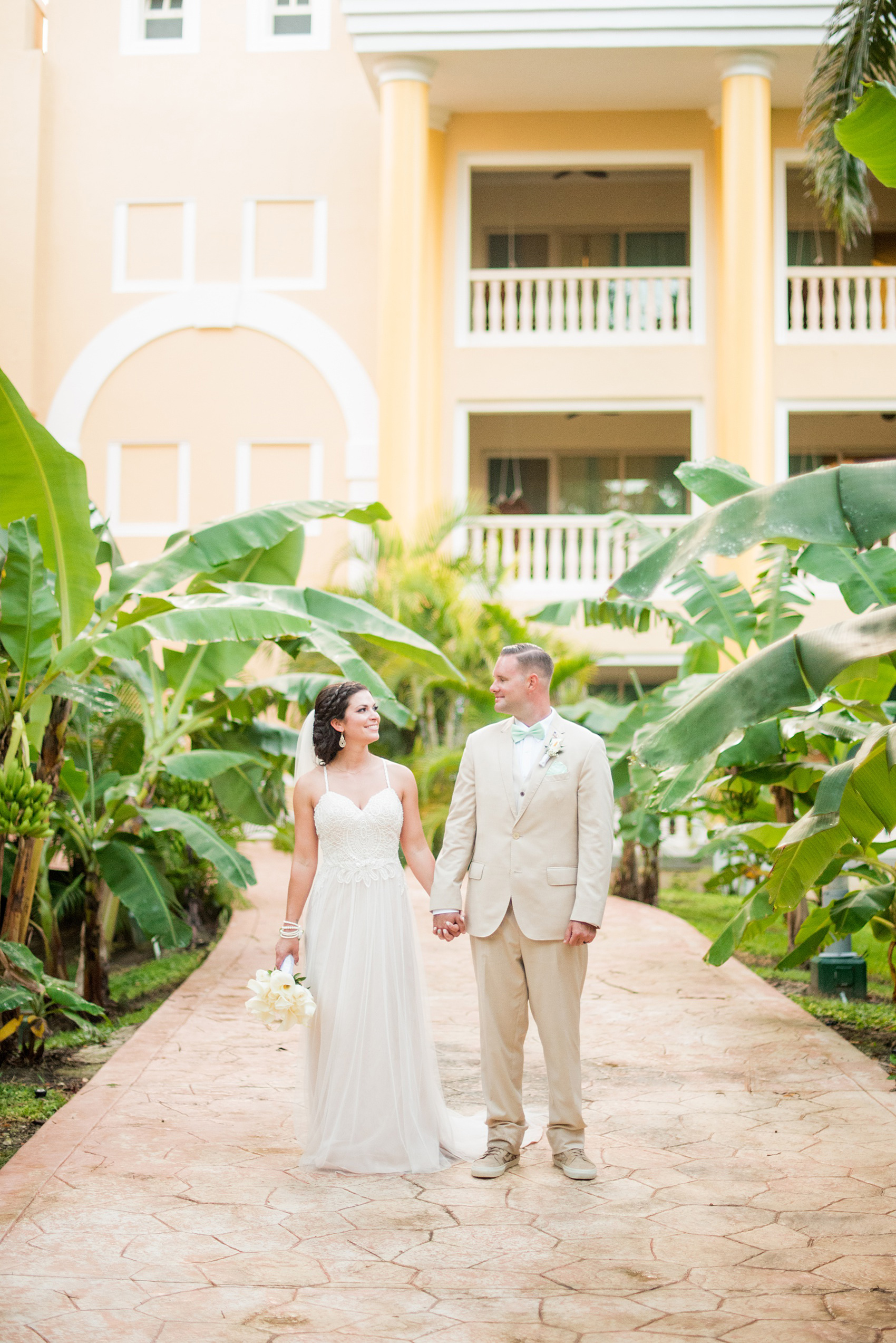 Mikkel Paige Photography photos from a wedding at Grand Paraiso, Mexico, Playa del Carmen Iberostar resort. Picture of the bride and groom in the tropical foliage at the resort.