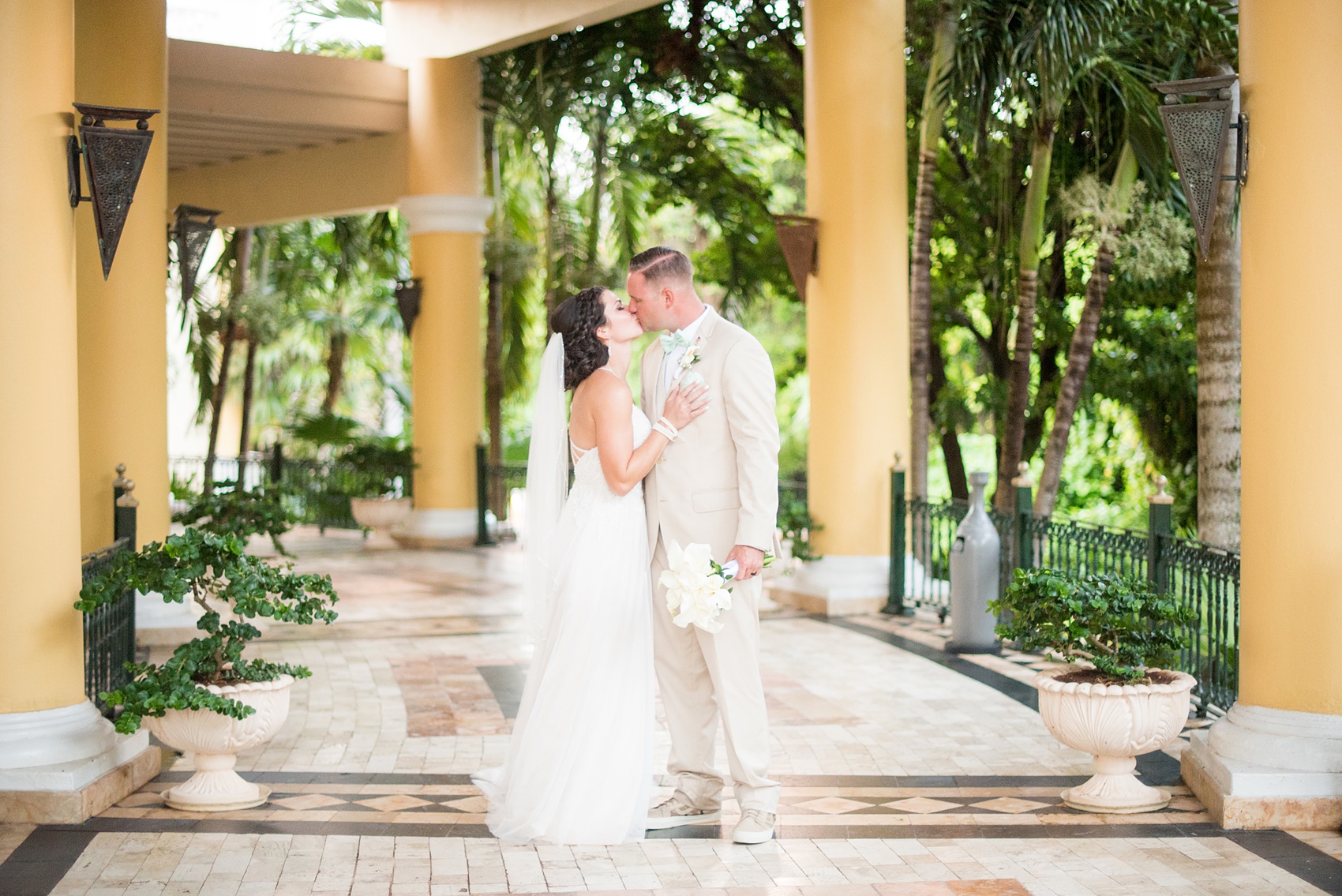 Mikkel Paige Photography photos from a wedding at Grand Paraiso, Mexico, Playa del Carmen Iberostar resort. Picture of the bride and groom kissing in the tropical foliage at the resort.