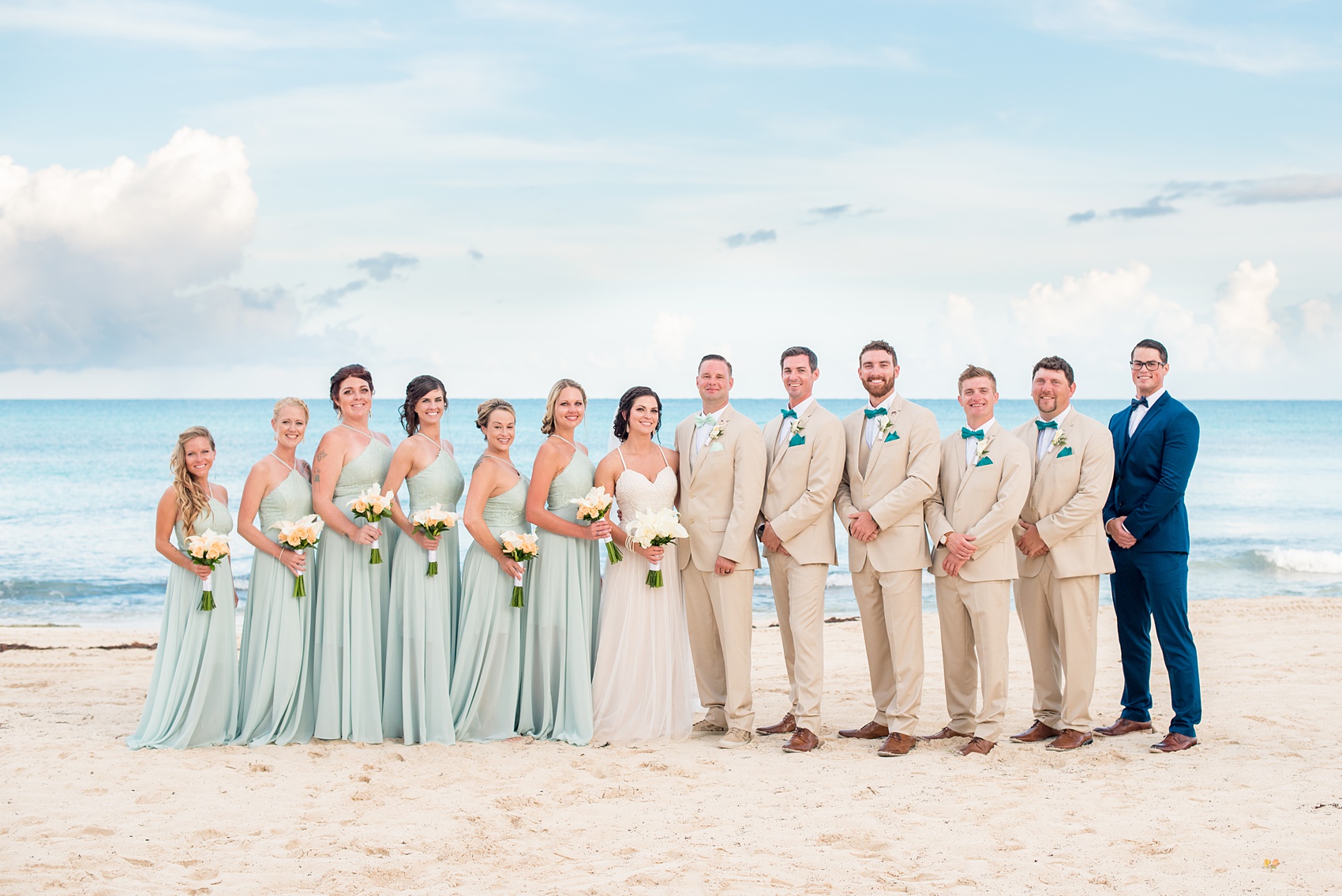 Mikkel Paige Photography photos from a wedding at Grand Paraiso, Mexico, Playa del Carmen Iberostar resort. Picture of the bridal party in mint green gowns and groomsmen in tan suits on the beach.