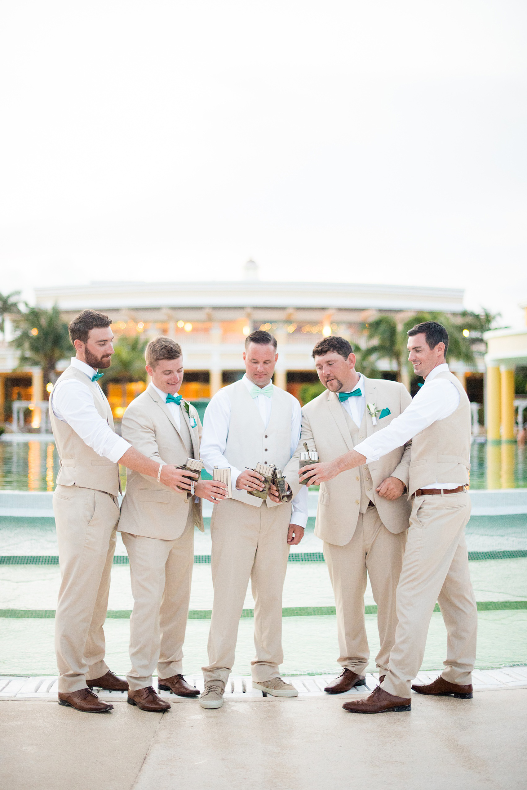 Mikkel Paige Photography photos from a wedding at Grand Paraiso, Mexico, Playa del Carmen Iberostar resort. Picture of the groomsmen with their army, military flasks from the groom.