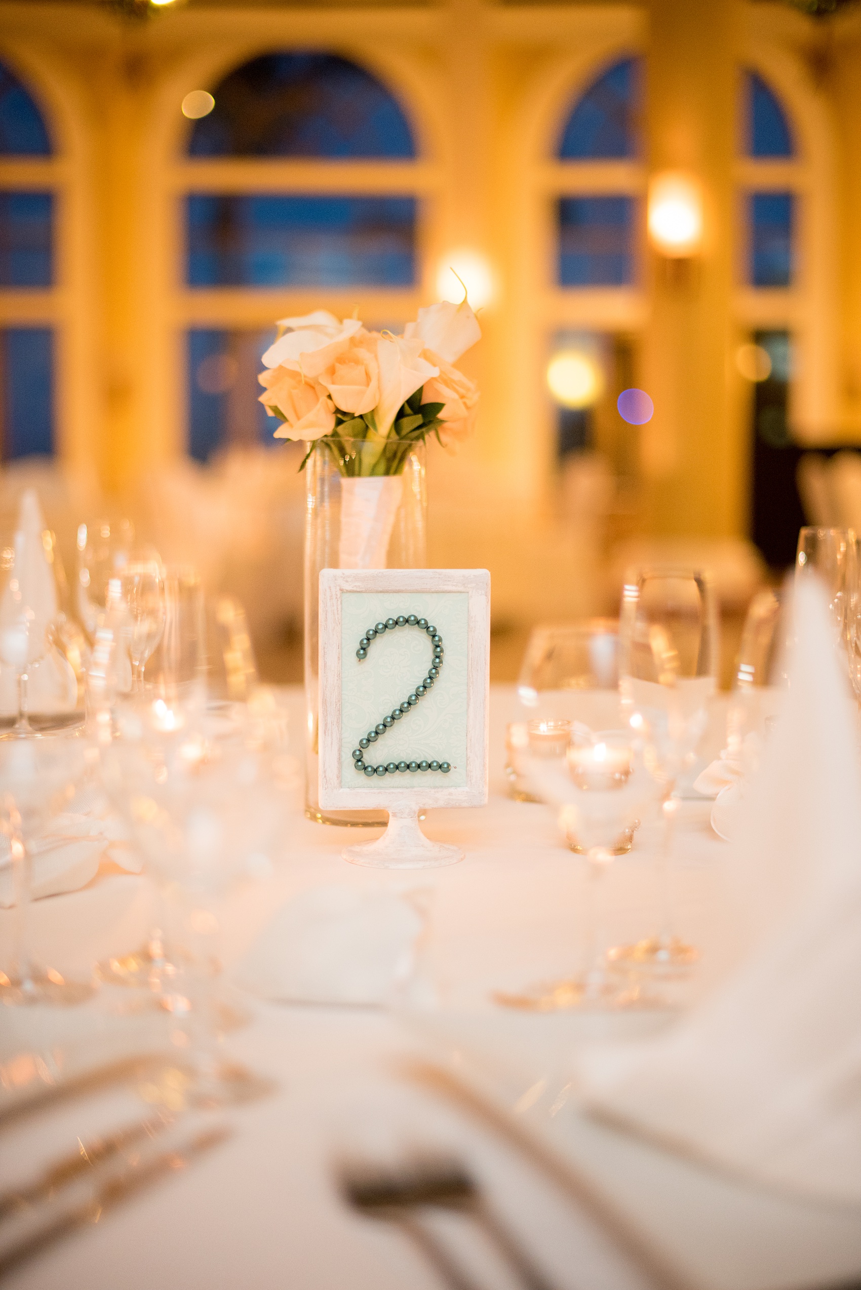 Mikkel Paige Photography photos from a wedding at Grand Paraiso, Mexico, Playa del Carmen Iberostar resort. Detail picture of the pearl and driftwood frame table number during the reception.