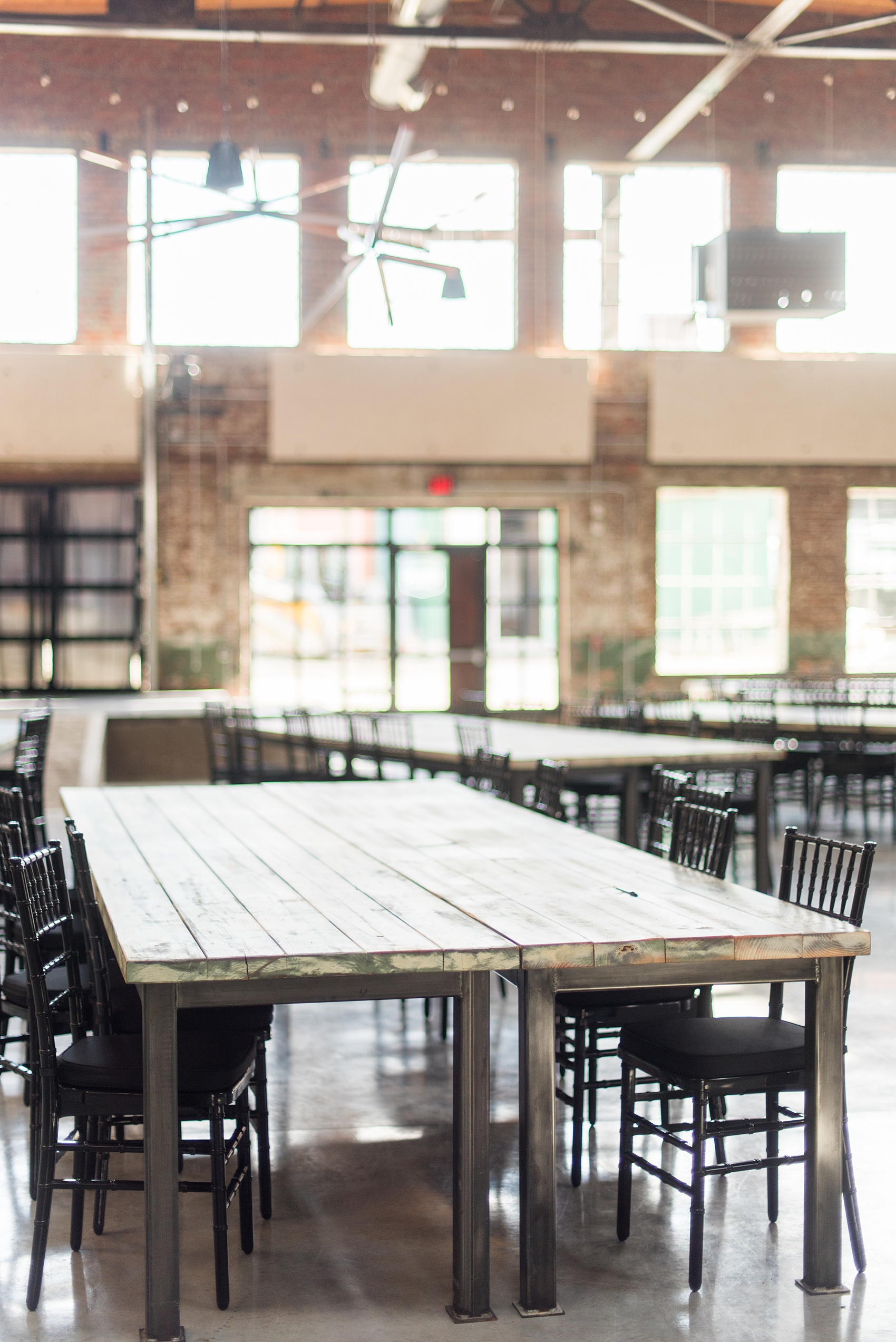 Mikkel Paige Photography pictures of Cadillac Service Garage venue in Greensboro, North Carolina. Photo of the interior farm tables.