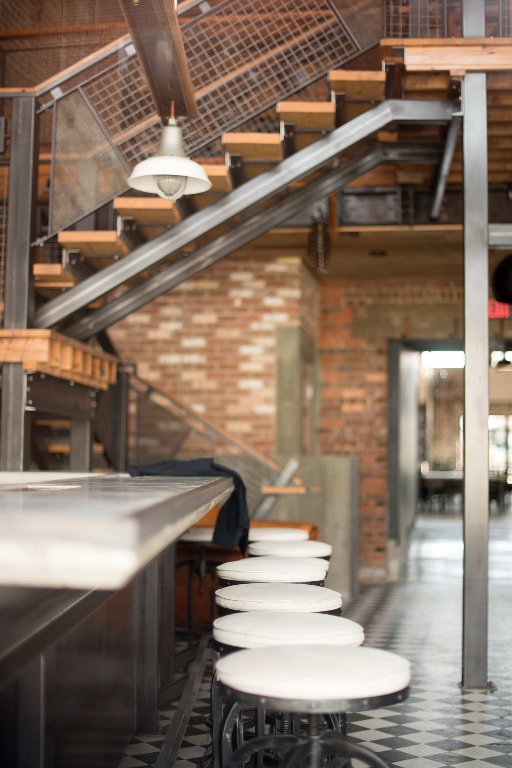 Mikkel Paige Photography pictures of Cadillac Service Garage venue in Greensboro, North Carolina. Photo of the interior front bar area and white bar stools.