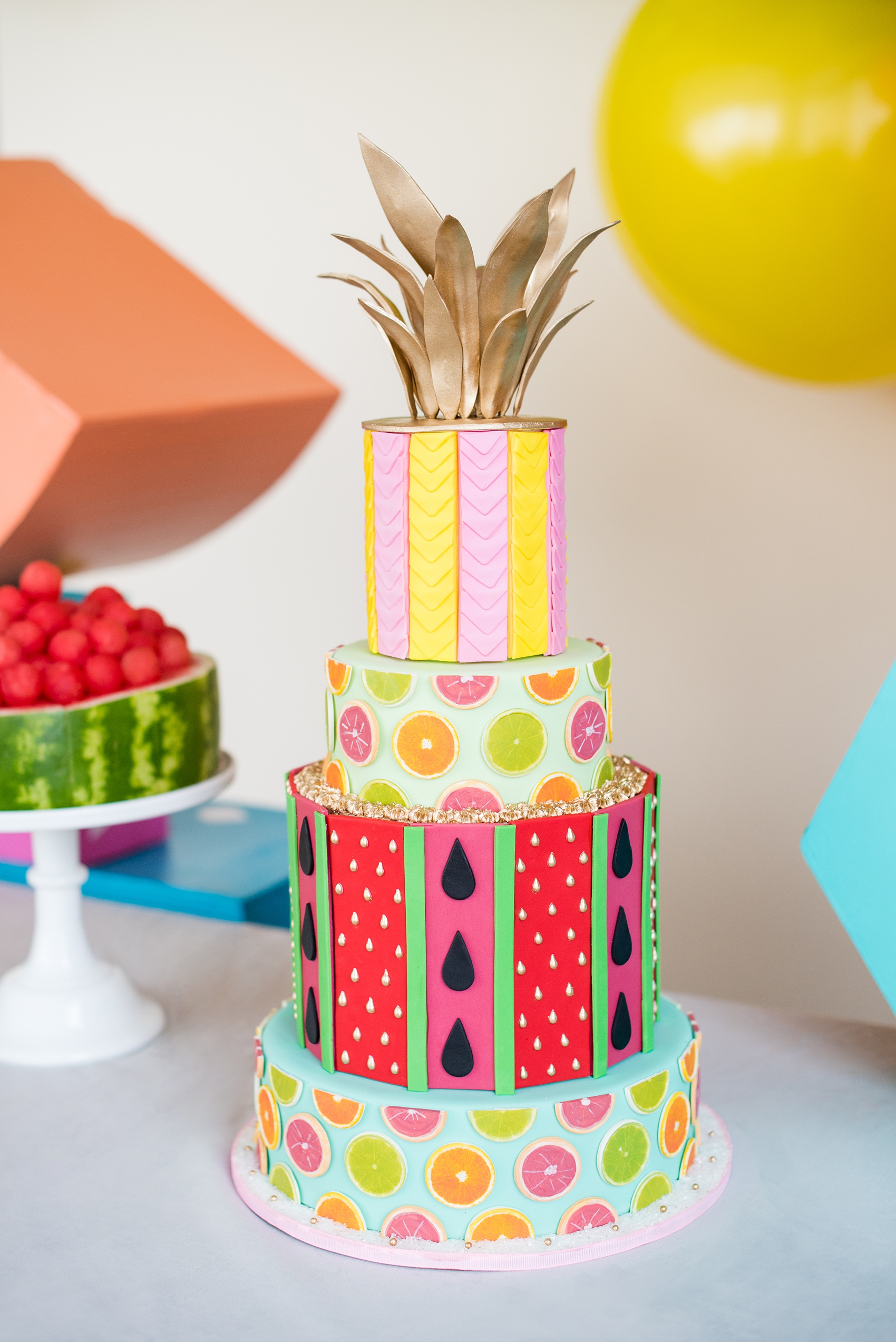 Mikkel Paige Photography photos of a Tutti Frutti theme birthday party. Featured on Martha Stewart. Planning by Color Pop Events, fruit cake with watermelon, limes and lemon a pineapple crown in gold luster dust by Sugar Monster.