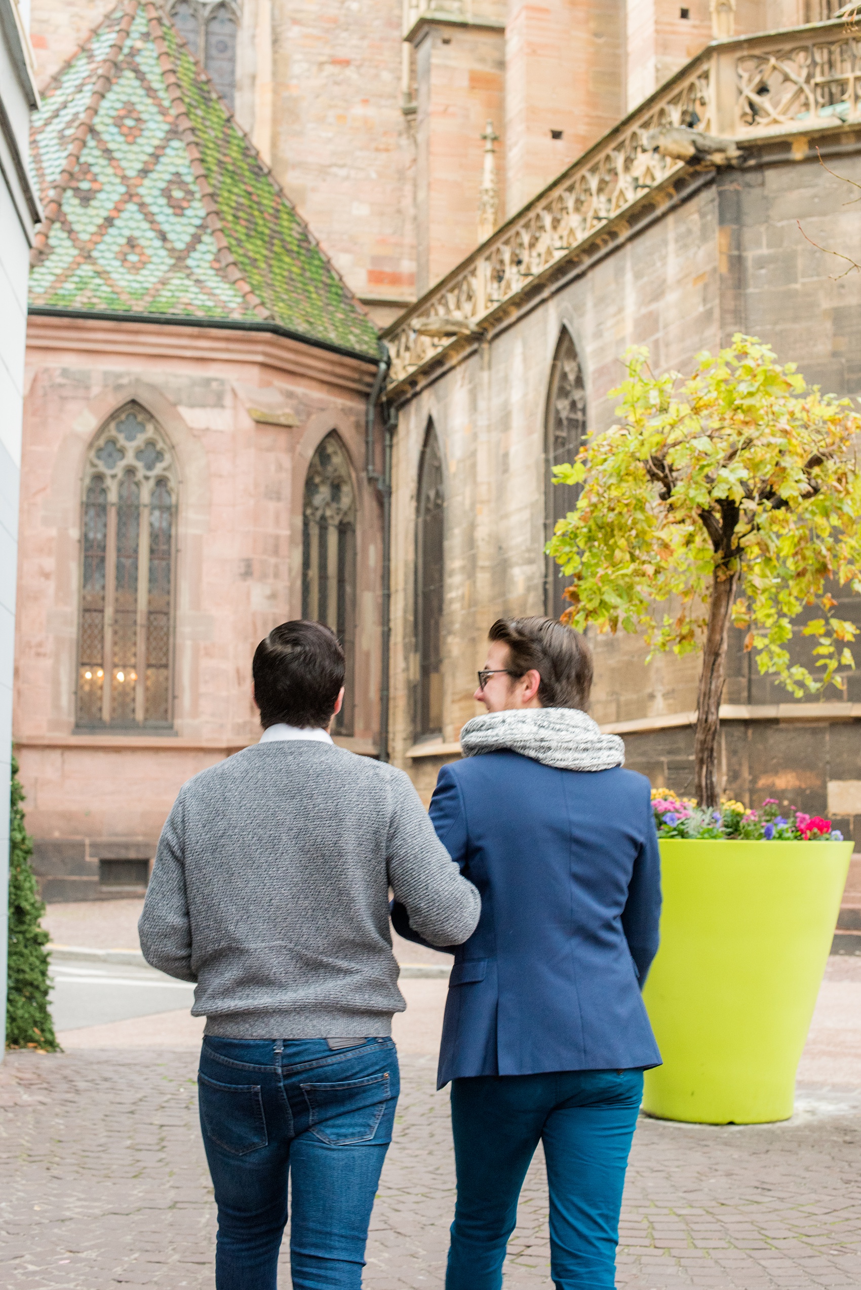 Mikkel Paige Photography pictures of an engagement session in Colmar, France in the Alsace region. Photo of the same sex couple walking through the cobblestone streets of the historic village.